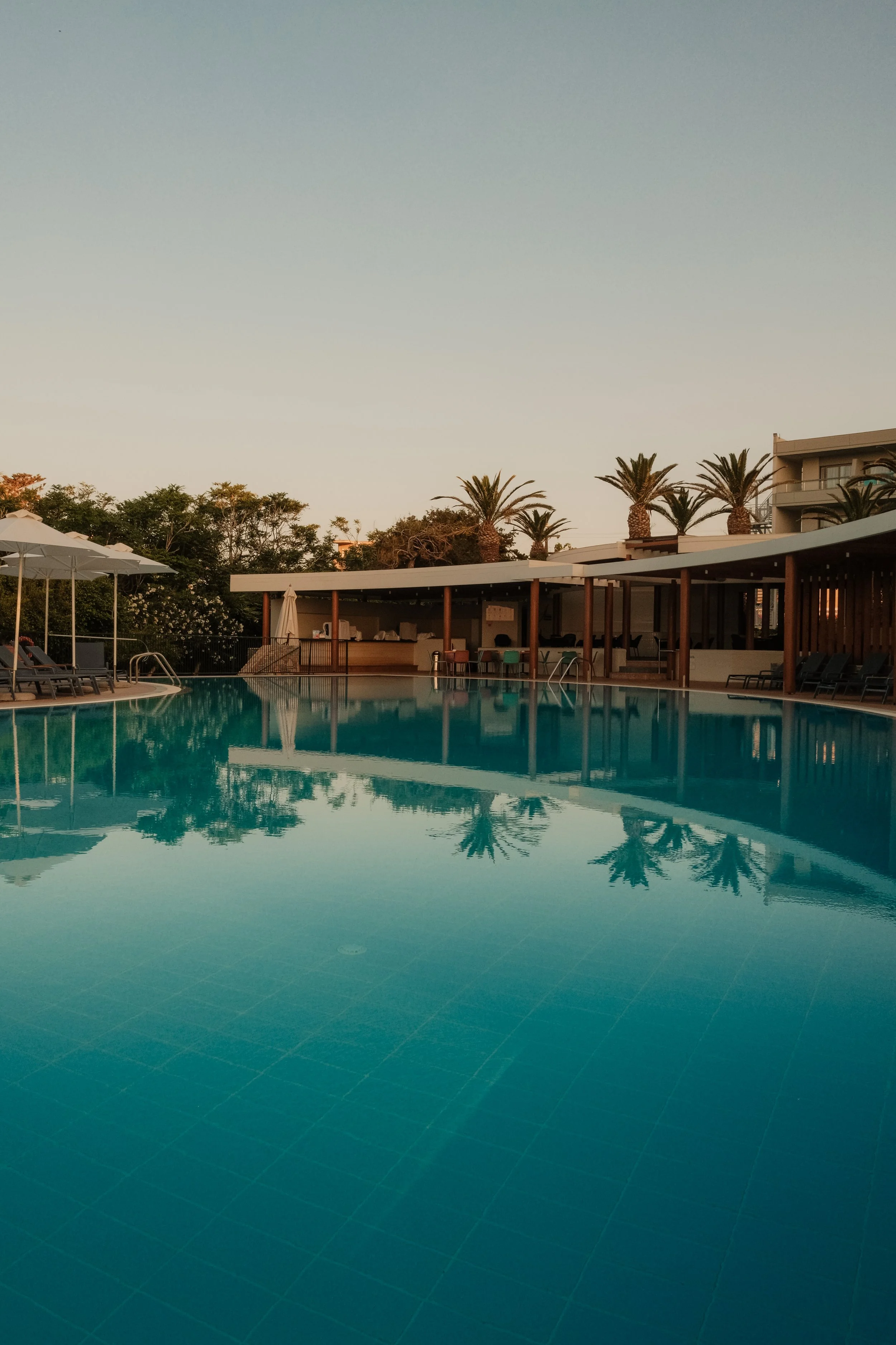 agapi-beach-resort-crete-greece-pool-reflection-palm-trees-pergola-dusk-hospitality-photography-22.jpg