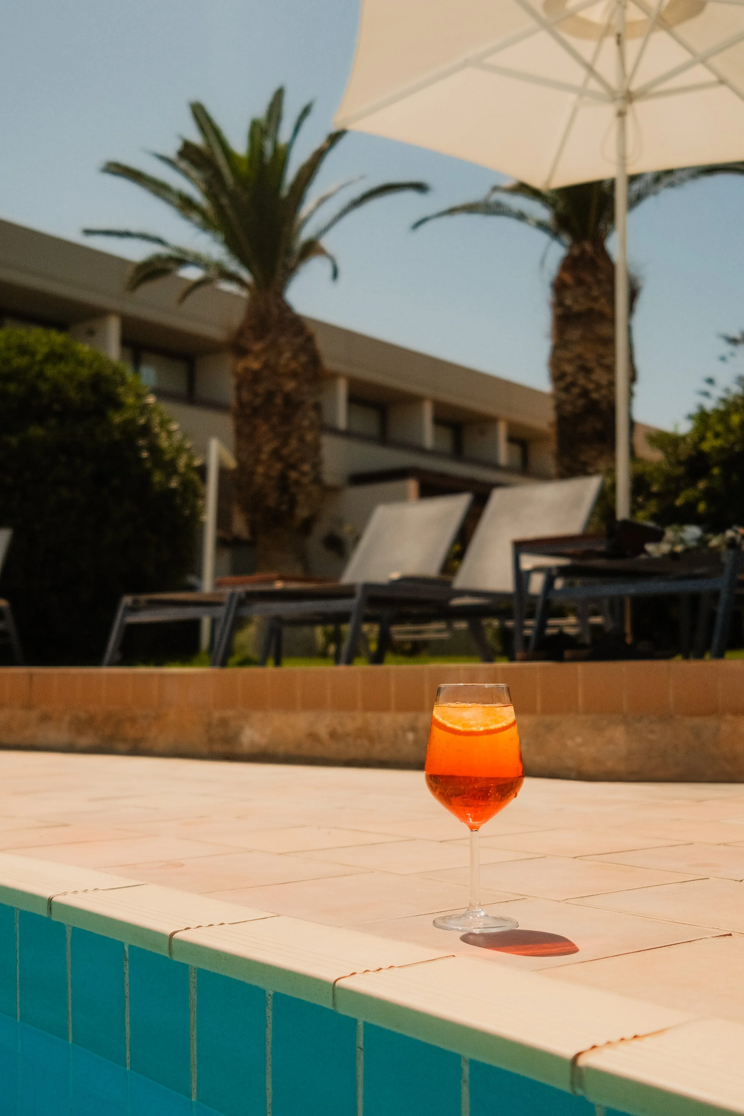 agapi-beach-resort-crete-greece-pool-aperol-spritz-cocktail-palm-lounge-chairs-hospitality-photography-28.jpg