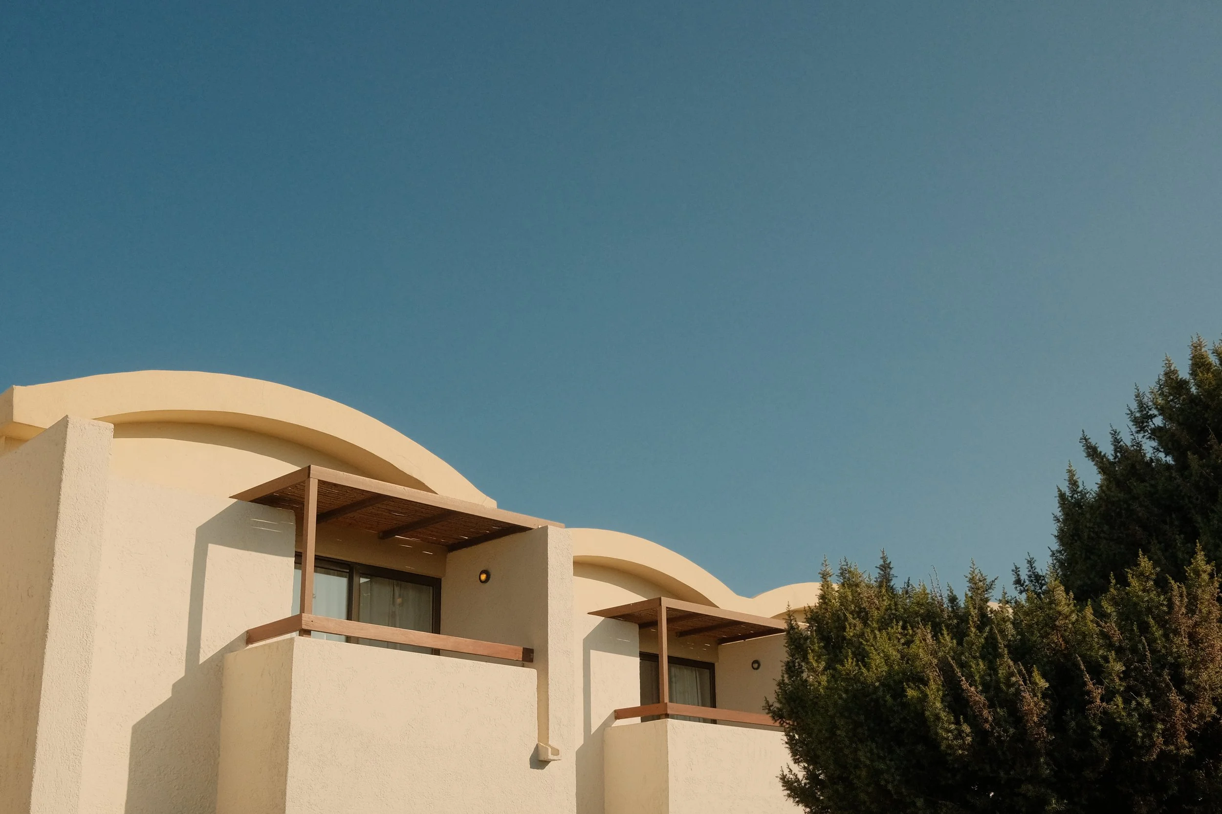 agapi-beach-resort-crete-greece-bungalow-wavy-roofline-white-architecture-blue-sky-hospitality-photography-33.jpg