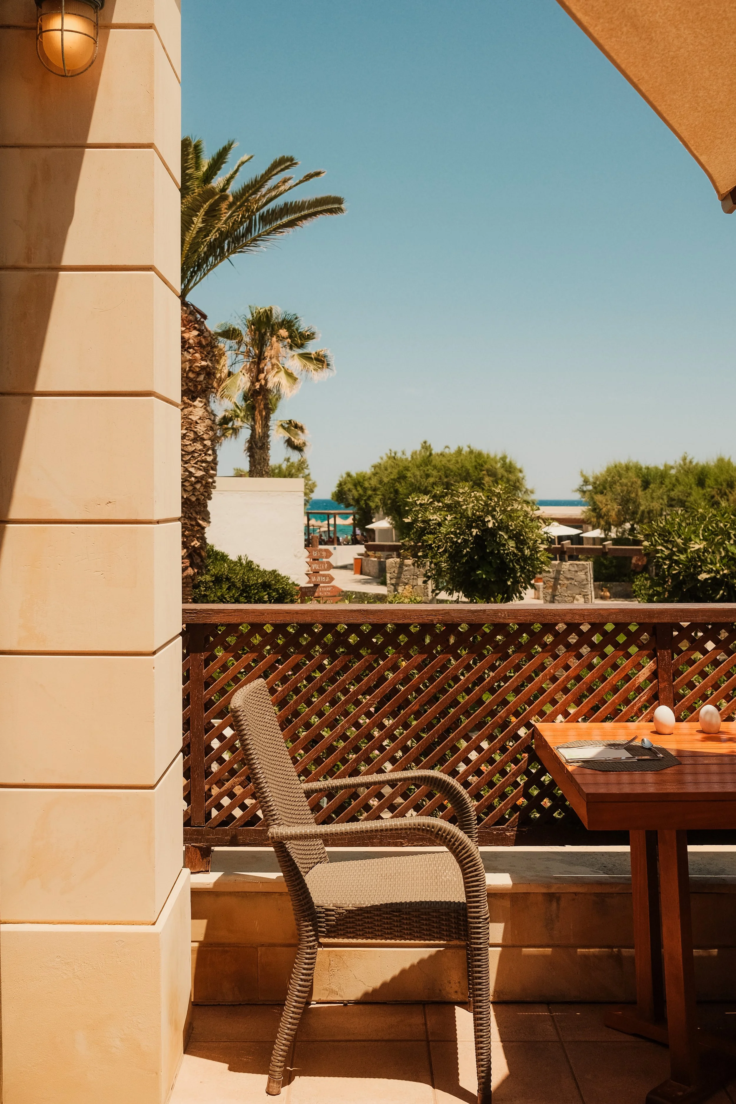 agapi-beach-resort-crete-greece-hotel-terrace-wicker-chair-palm-tree-sea-view-hospitality-photography-01.jpg