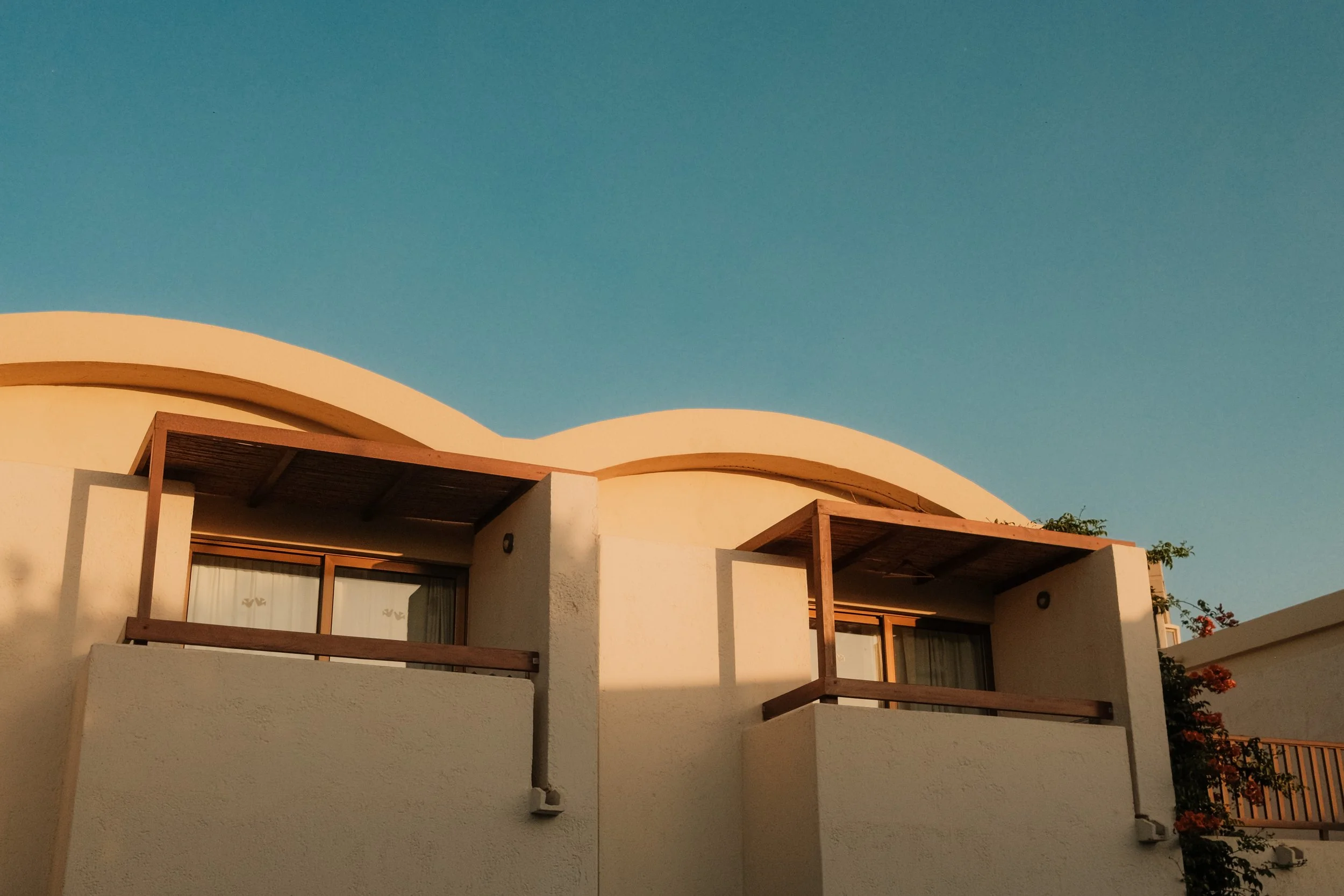 agapi-beach-resort-crete-greece-bungalow-wavy-roofline-architecture-golden-hour-hospitality-photography-20.jpg