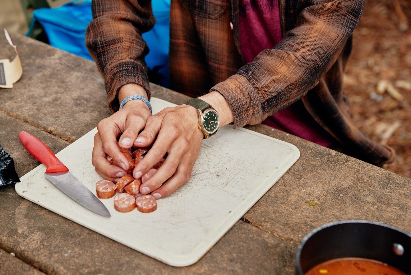 man gathering cut food into his hands on top of a cutting board