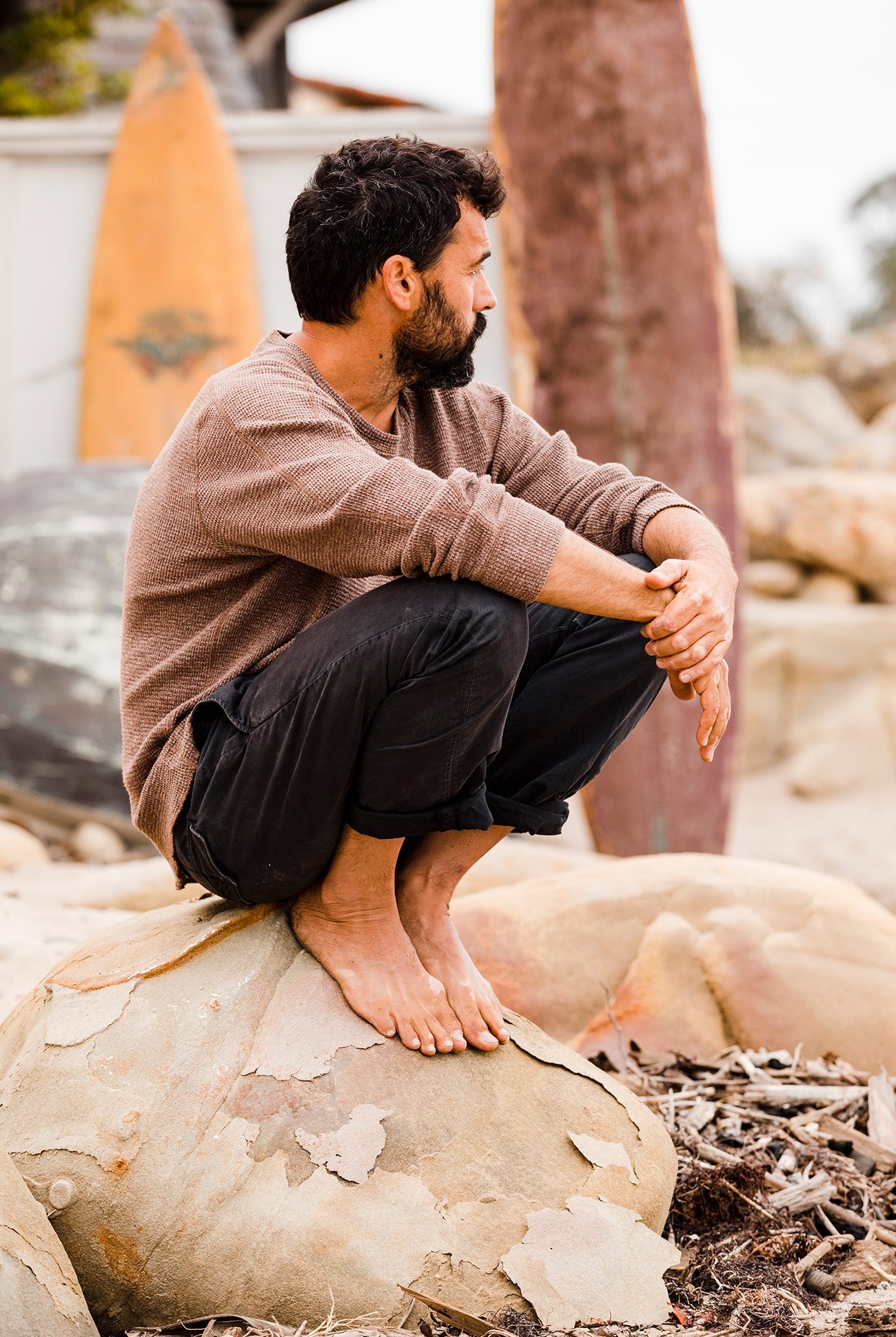 man sitting on a rock with both knees up