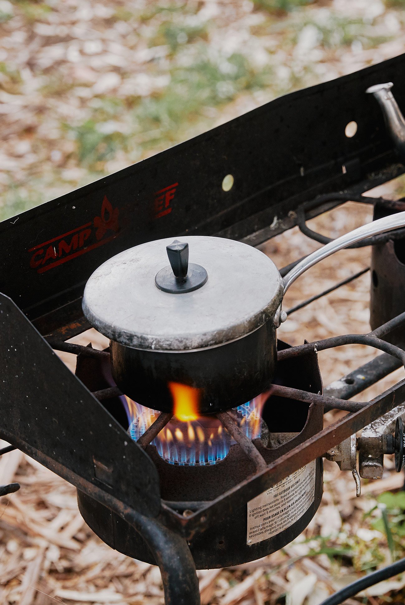 a small cooking pot heating up over a camp stove