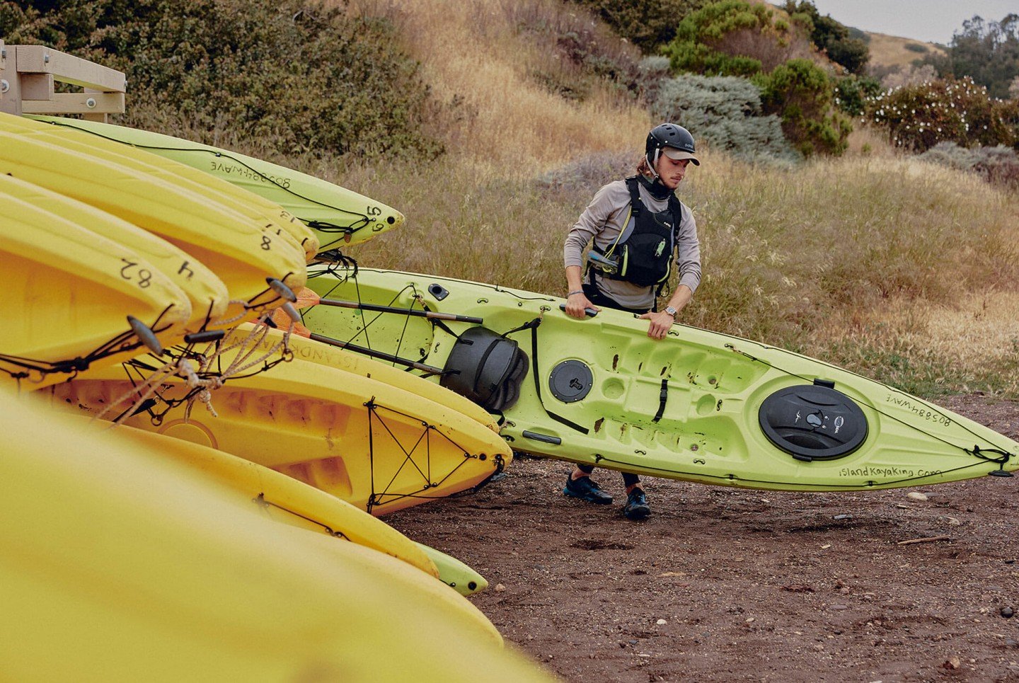 man hauling a green kayak