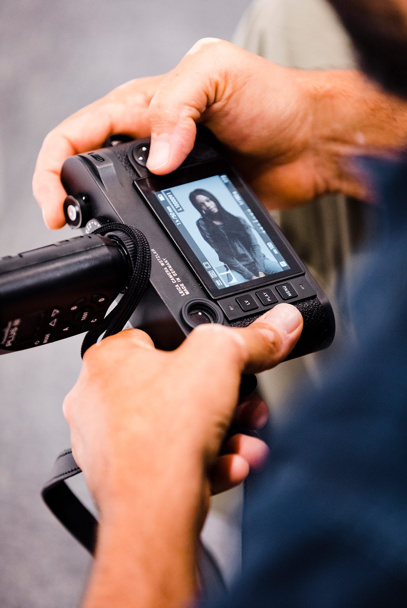 man looking at the photo he just took of a woman on the LED screen of his camera