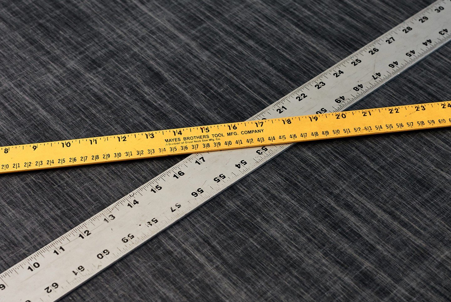 a measuring tape and a ruler crossed over each other