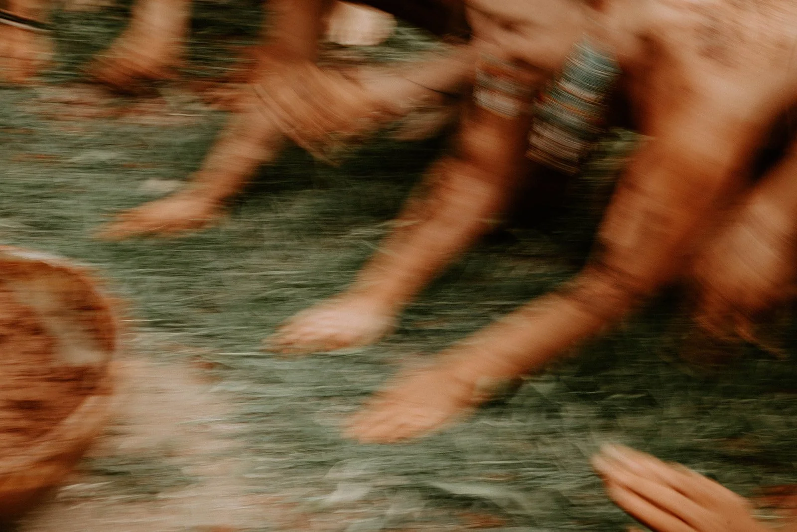 The image appears to be blurry and shows dog paws on the ground, possibly with the surrounding environment, but specific details are unclear.