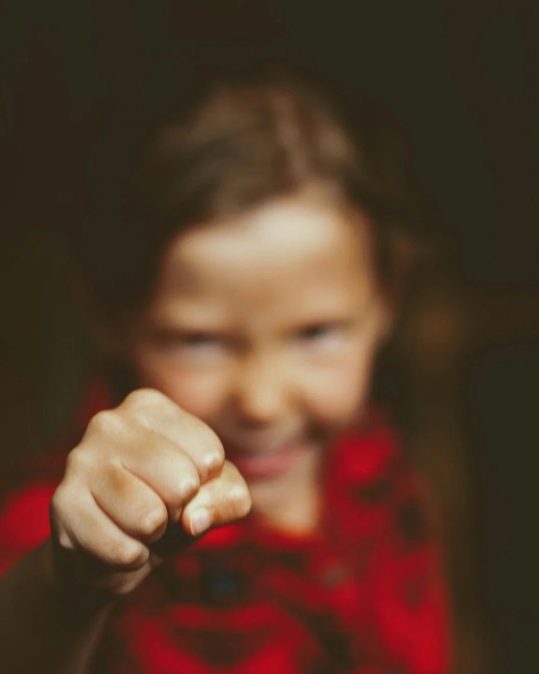 Willensstarkes Kind zeigt Eltern die Faust und will sich durchsetzen