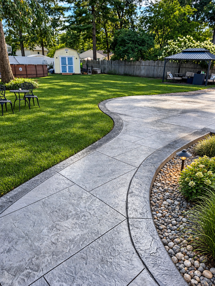 Gray stamped concrete walkway with a medium gray border and landscape lighting