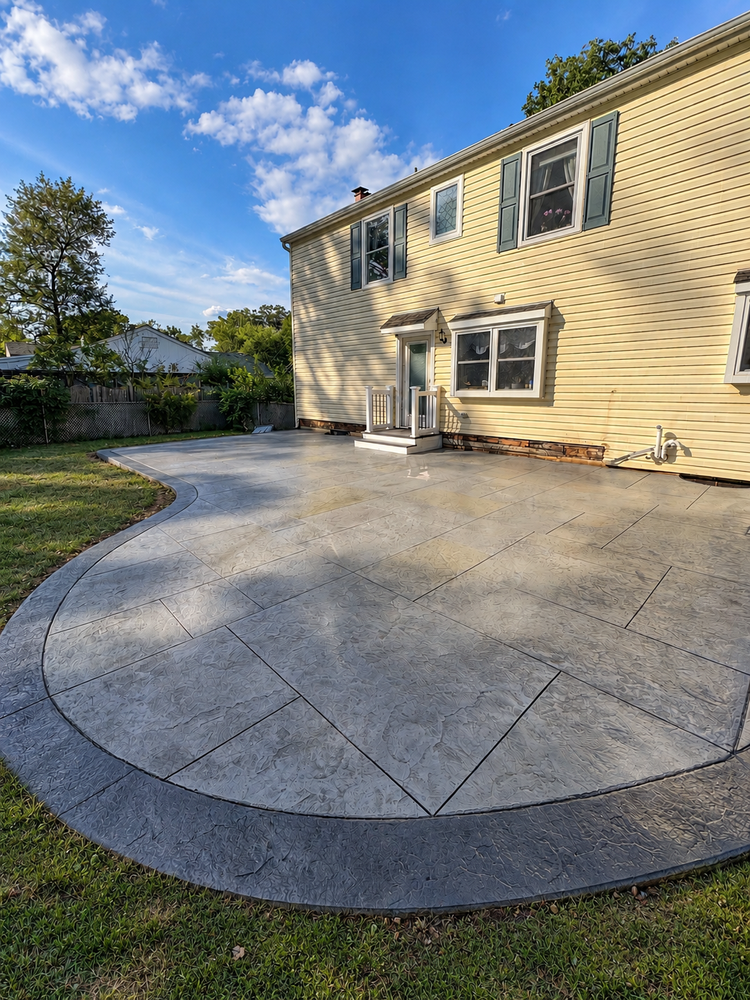 Large ashlar slate stamped concrete patio with a curved border