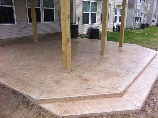 Stamped concrete patio installed under existing deck in Bellmawr NJ - Large Ashlar Slate Desert Tan by Patrick Breen Masonry