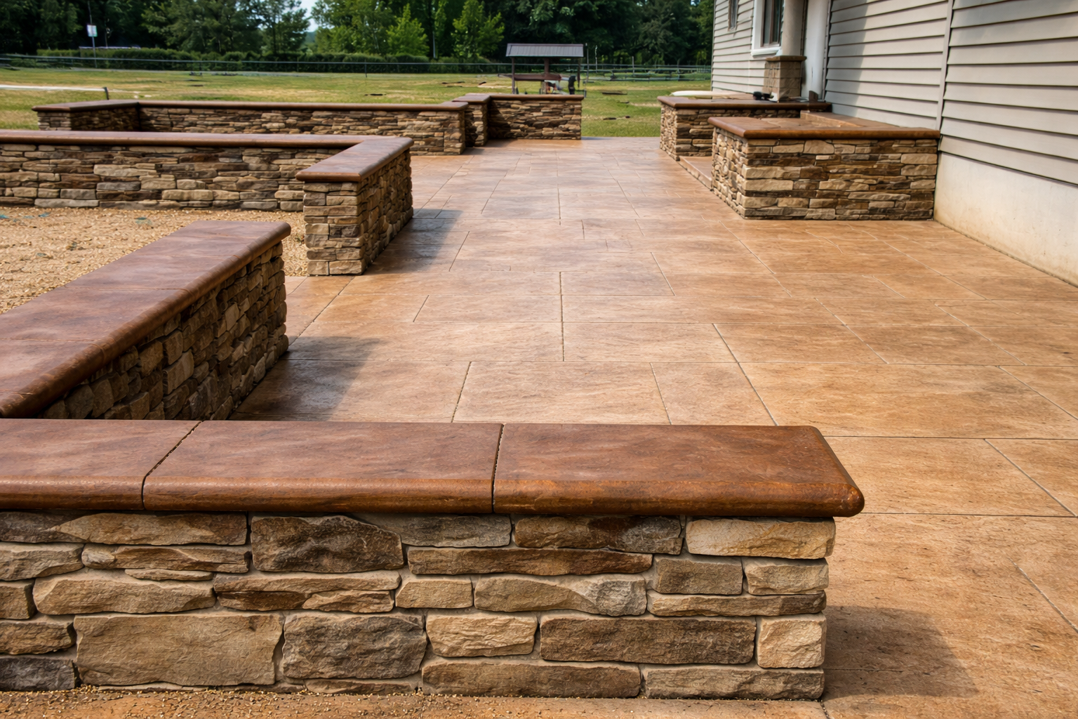 A newly constructed outdoor patio with sandstone walls and tiled flooring in a backyard setting.