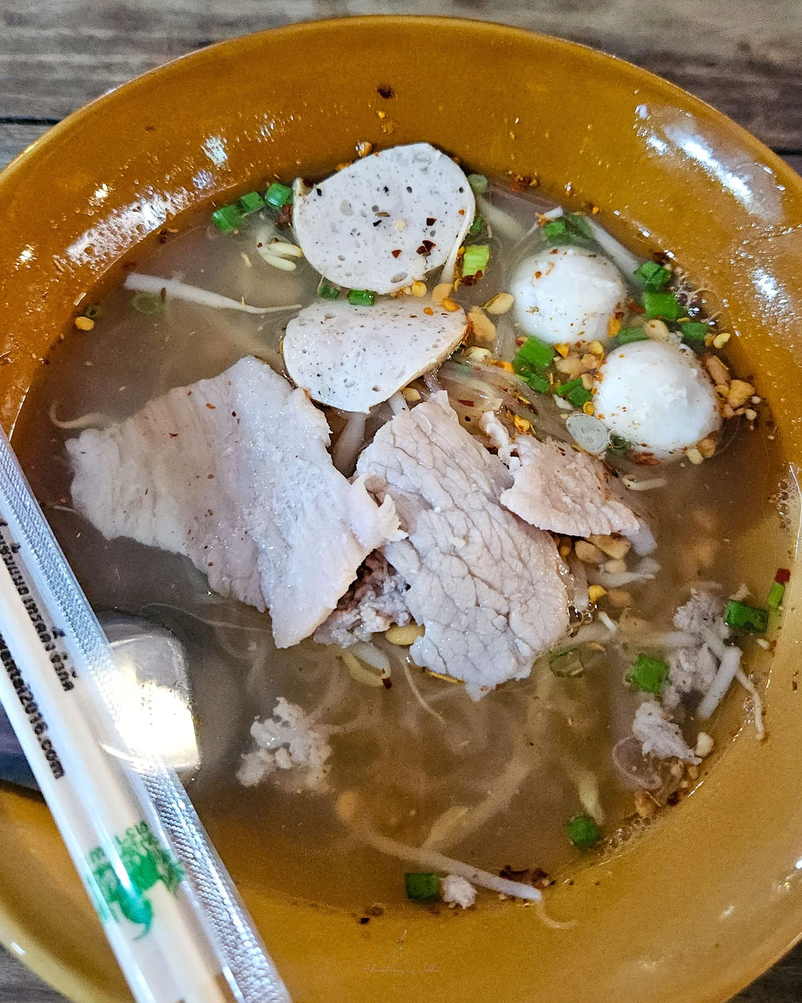 A bowl of pork rice noodle soup containing sliced pork Vietnamese sausage, slices of pork, pork balls, beansprouts and chopped peanuts at the Tong Paet Market Food Court in Khon Kaen, Isan.