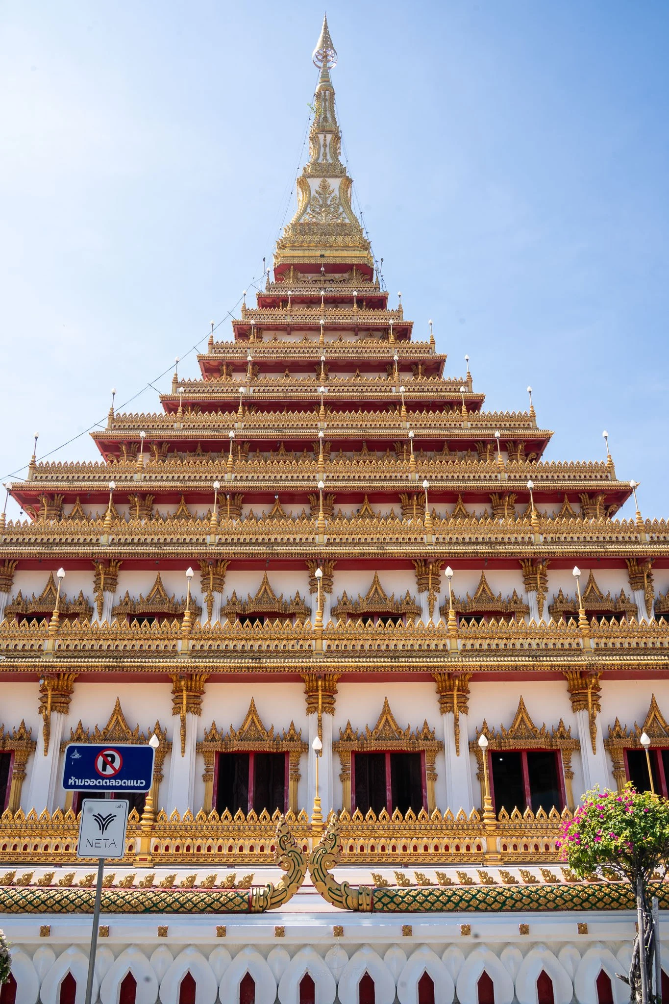 The red, white and gold pyramid layers of Phra Mahathat Kaen Nakhon (also known as Wat Nong Wang) temple tower over the viewer.
