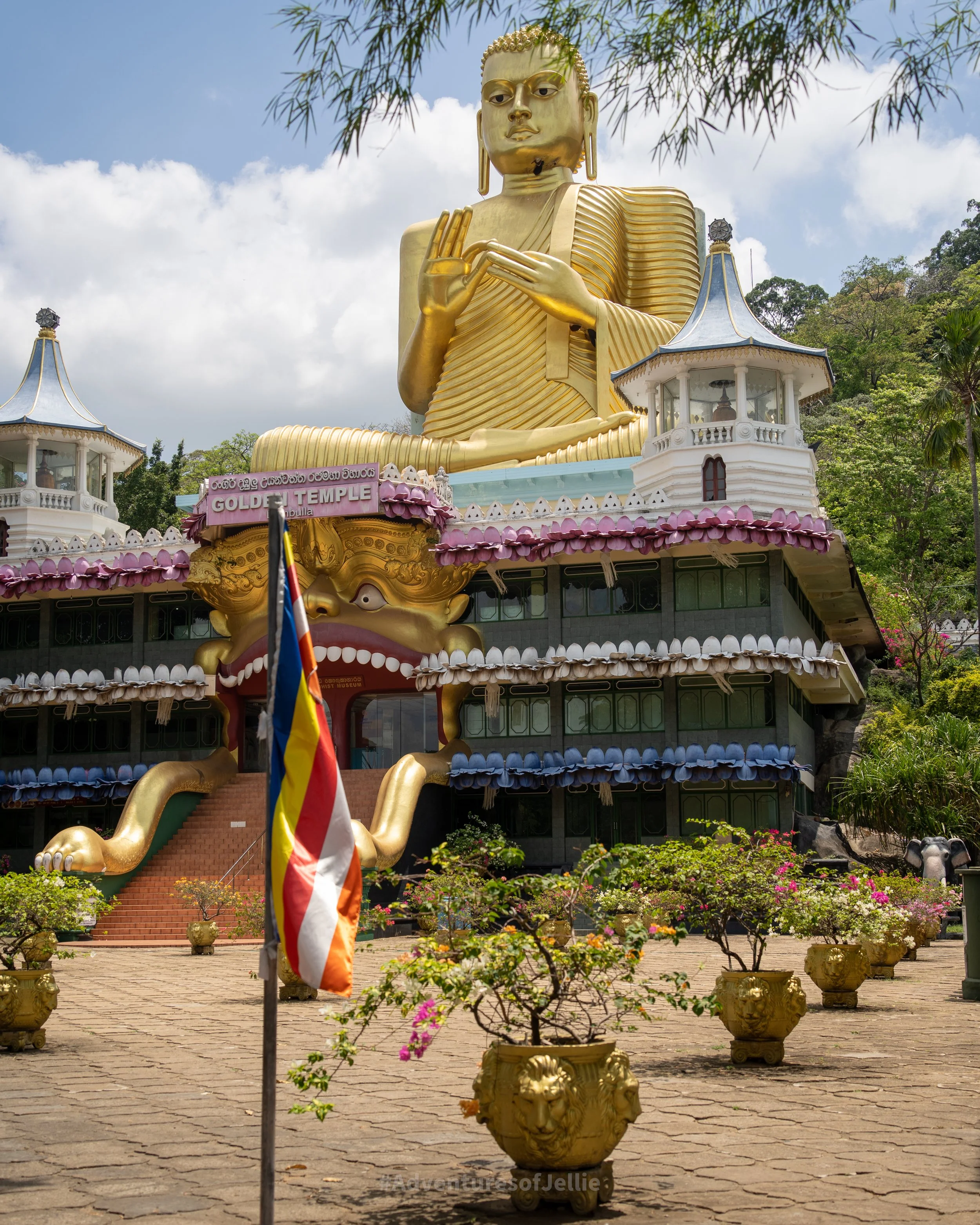The Giant Golden Buddha statue sits atop an ornate temple at the base of the Dambulla Royal Cave Temple