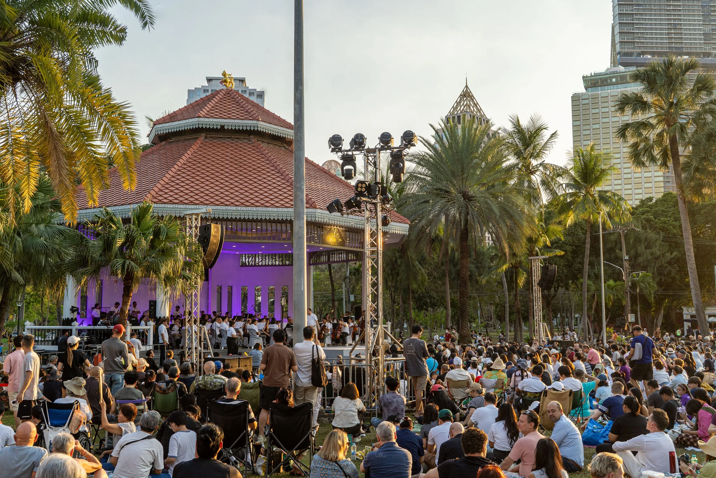 Crowds gather on the lawns in front of a bandstand in the middle of Lumphini Park in Bangkok.