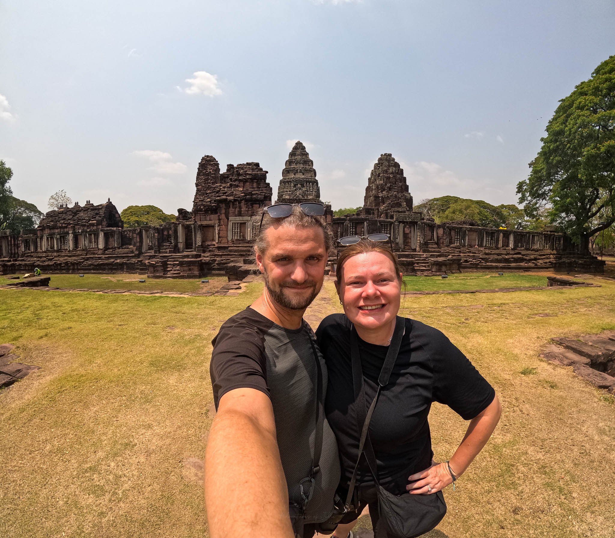 John and Ellie pose for a photo against the backdrop of the ancient temple ruins of Phimai Historical Park in Isan.