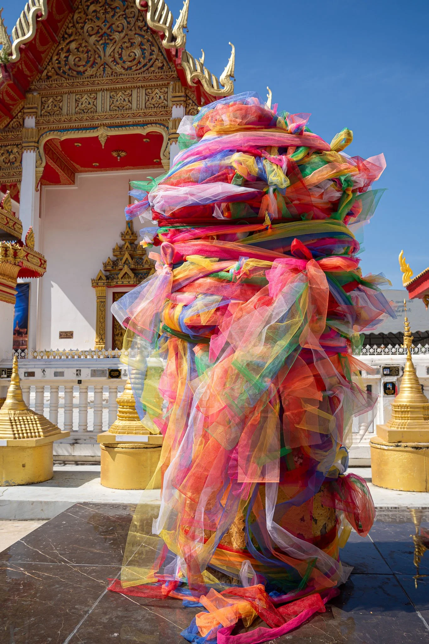 A pillar is wrapped in colourful swathes of material in the Wat That Phra Aram Luang temple grounds in Khon Kaen.