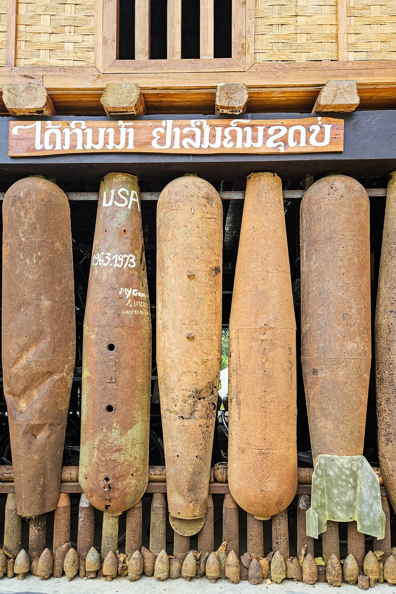The exterior wall of the Ban Pha Toke Community Museum is made up of rusty old bomb casings that were dropped on Laos during the Secret War.
