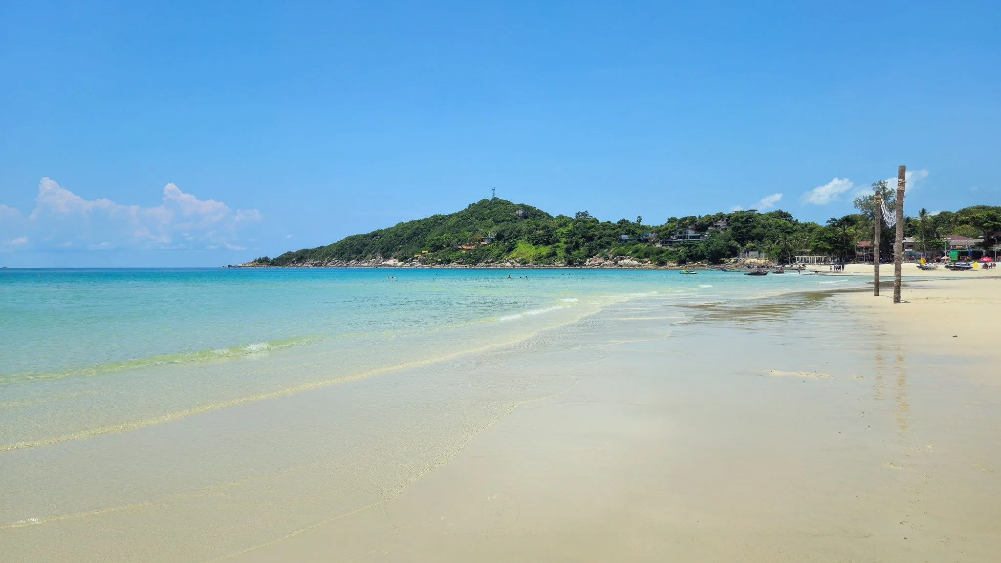 White sands and blue turquoise sea stretch away from the viewer at Haad Rin Beach on Koh Phangan.
