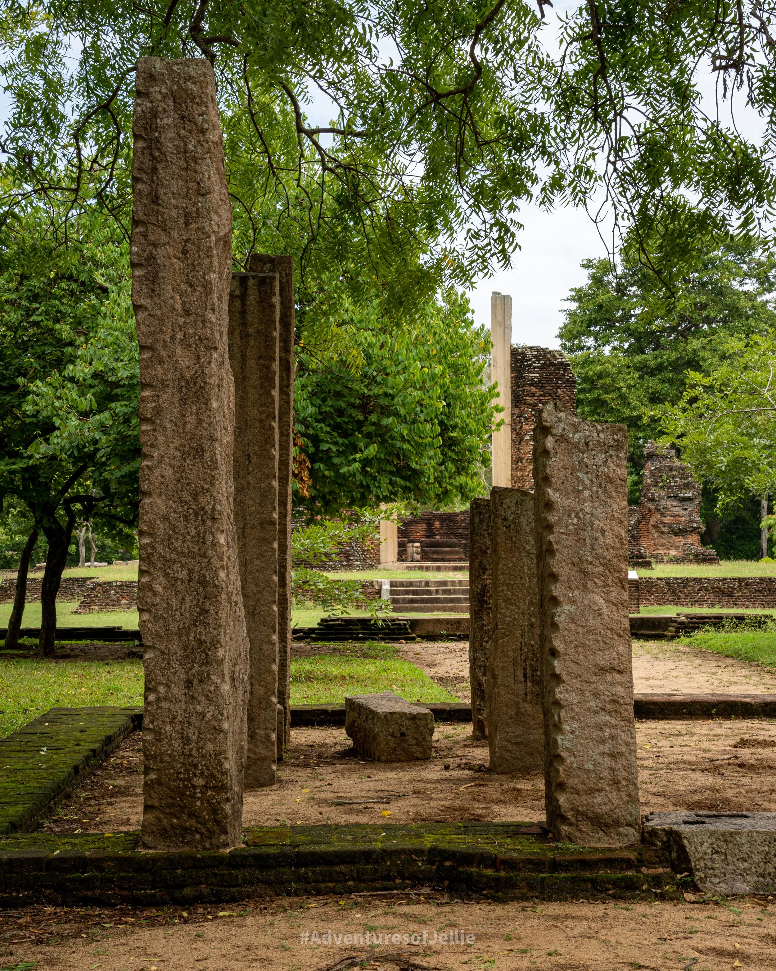 Four ruined square pillars stand, each at a different height. Shot in Anuradhapura's ancient city, Sri Lanka