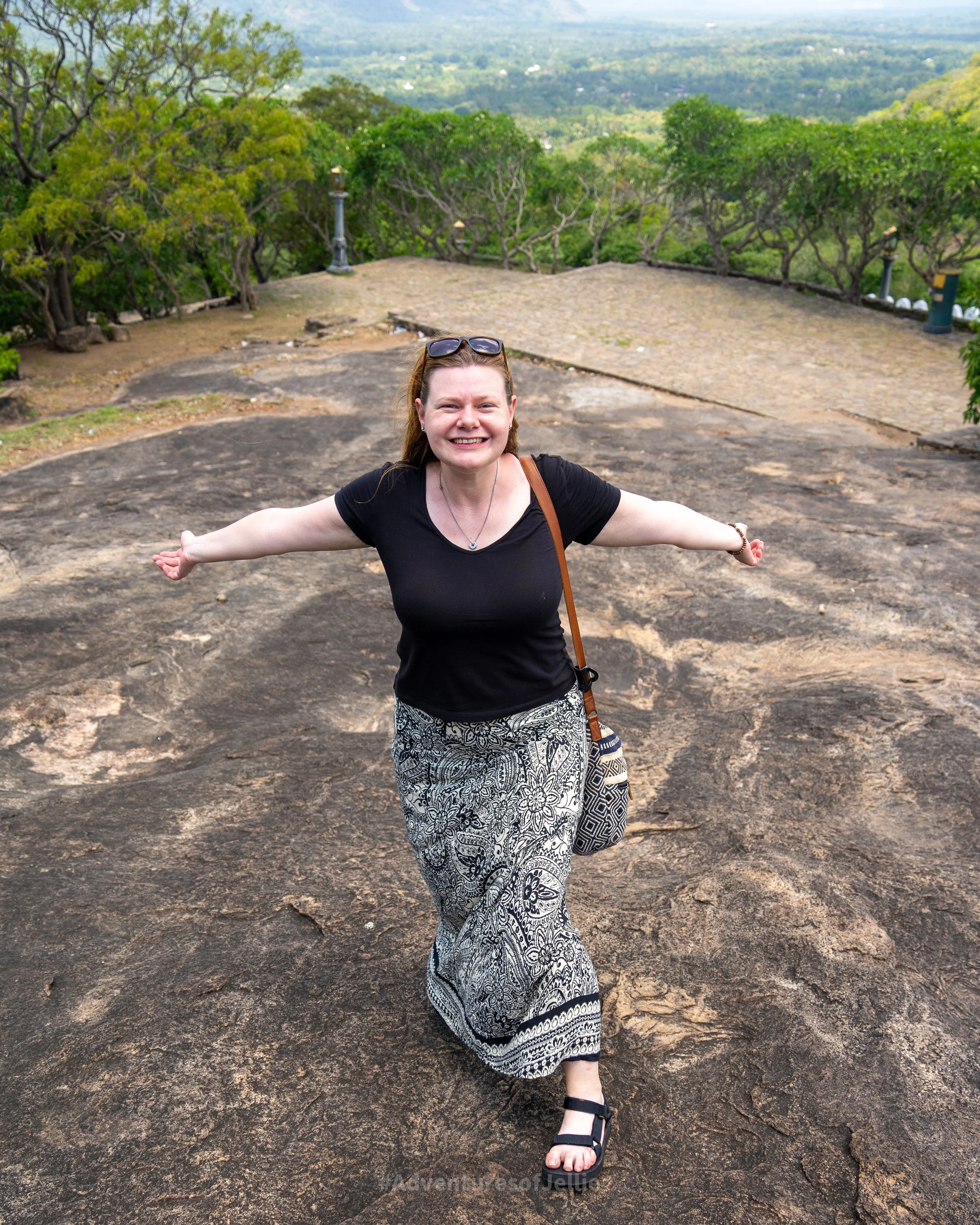Ellie poses in her Teva sandals at the top of a steep rock descent