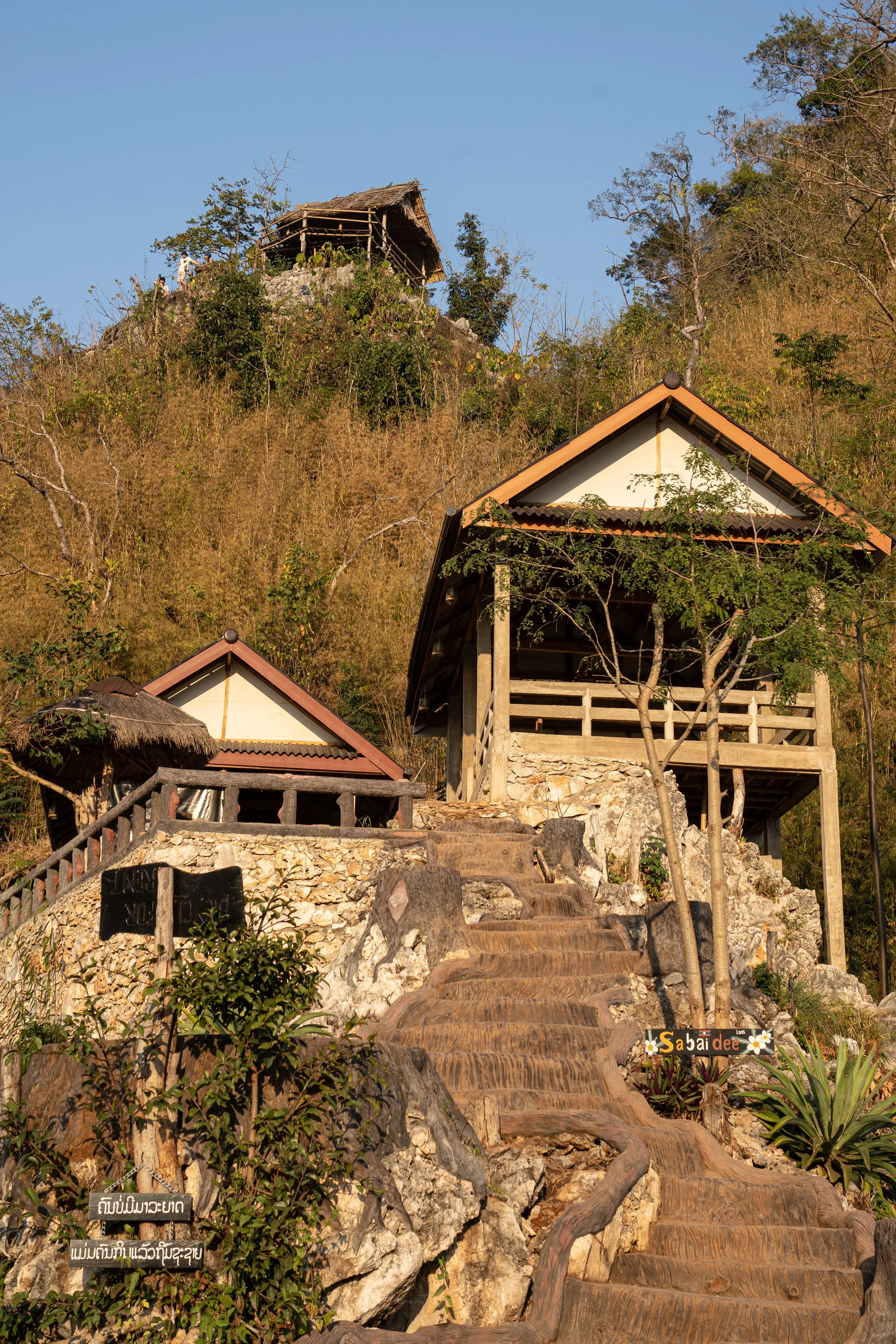 Steps lead up towards a shop and two sheltered viewing platforms at the top of the Som Nang Viewpoint trail in Nong Khiaw.