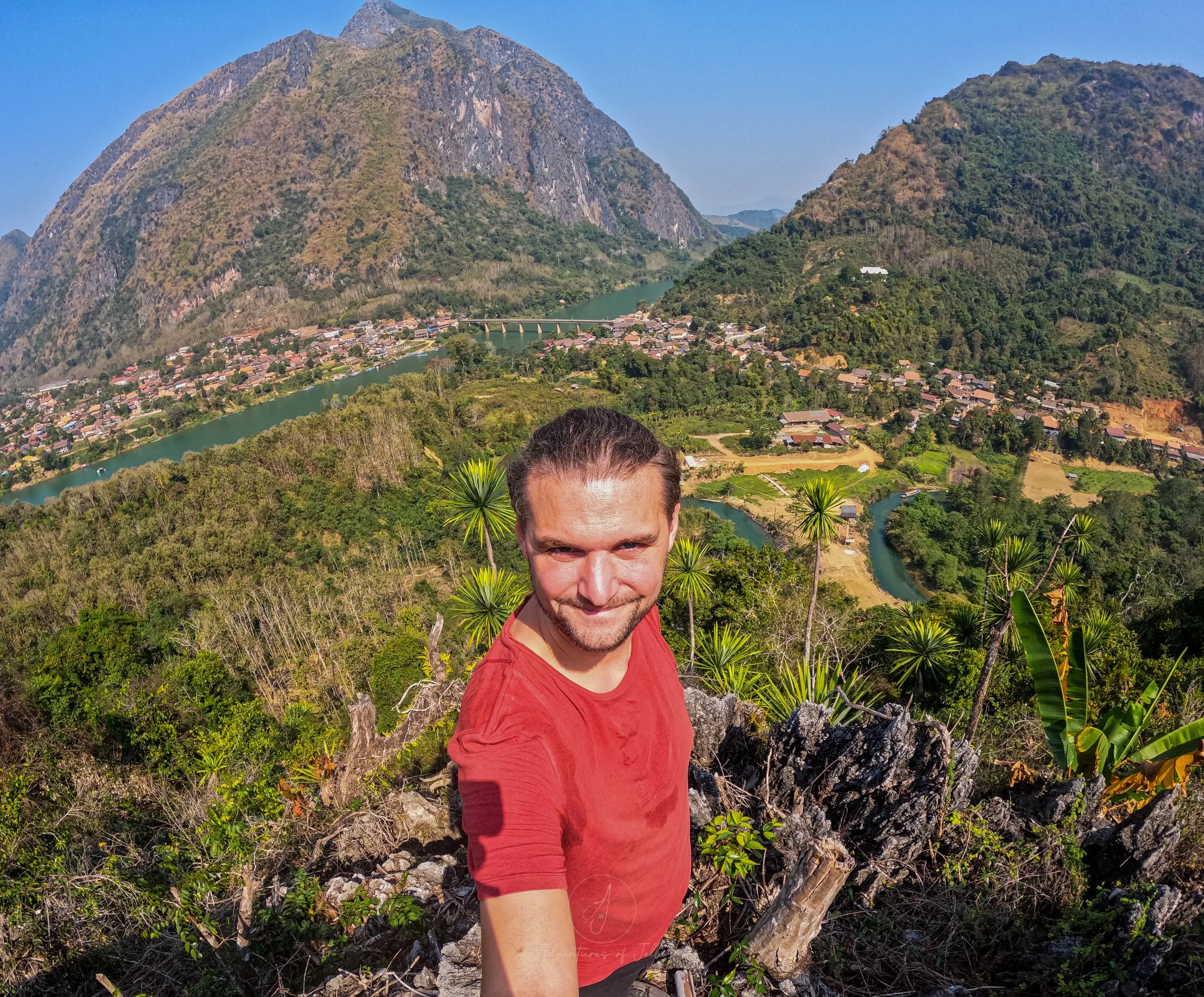 John poses for a selfie at the Pha Noi viewing platform in Nong Khiaw. Behind him the town, river and dramatic peaks stretch away.