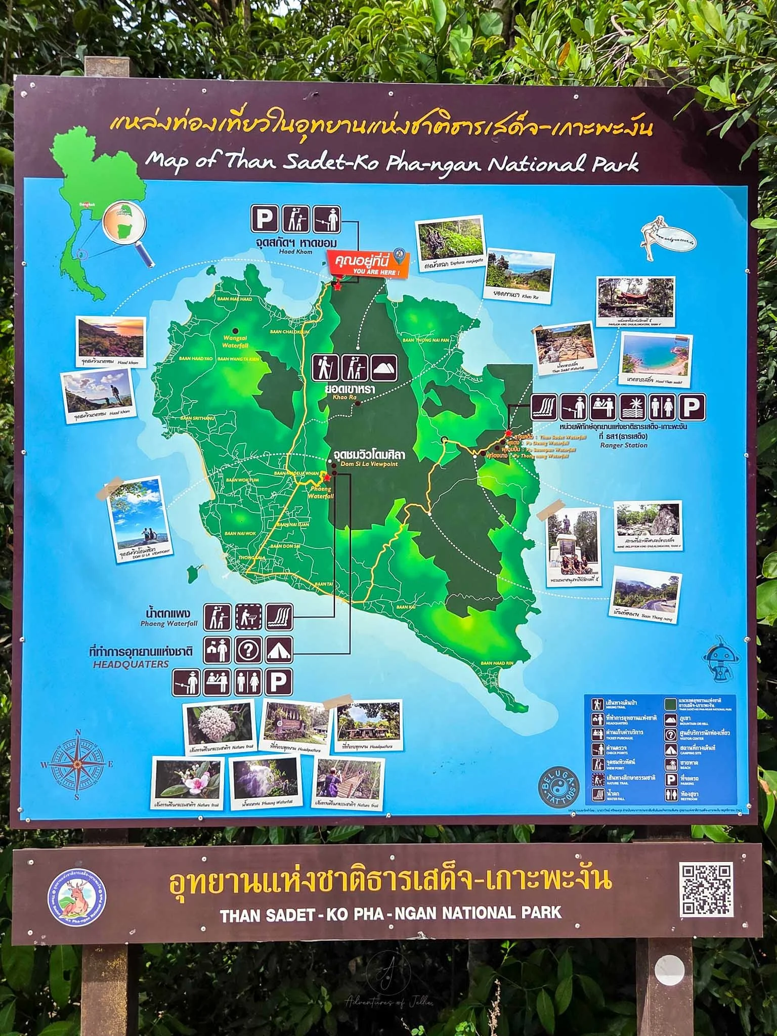 A wooden board displays a map of Koh Phangan and the Than Sadet National Park. The map shows what there is to see and do as well as car parks, toilets and park rangers.
