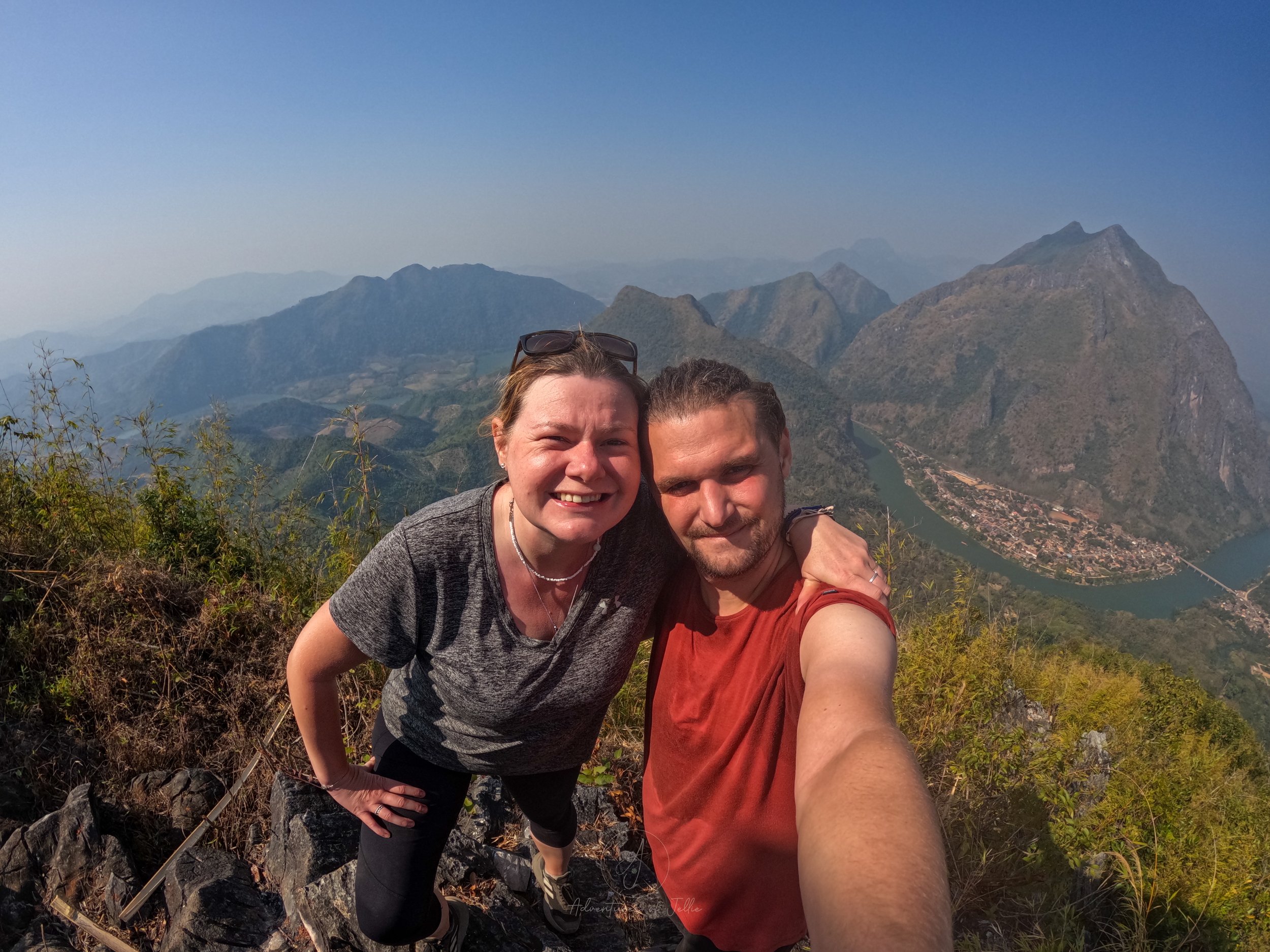 Adventures of Jellie take a GoPro selfie after hiking to the top of the Pha Kao viewpoint. Behind them the town of Nong Khiaw and the Nam Ou river stretch away.