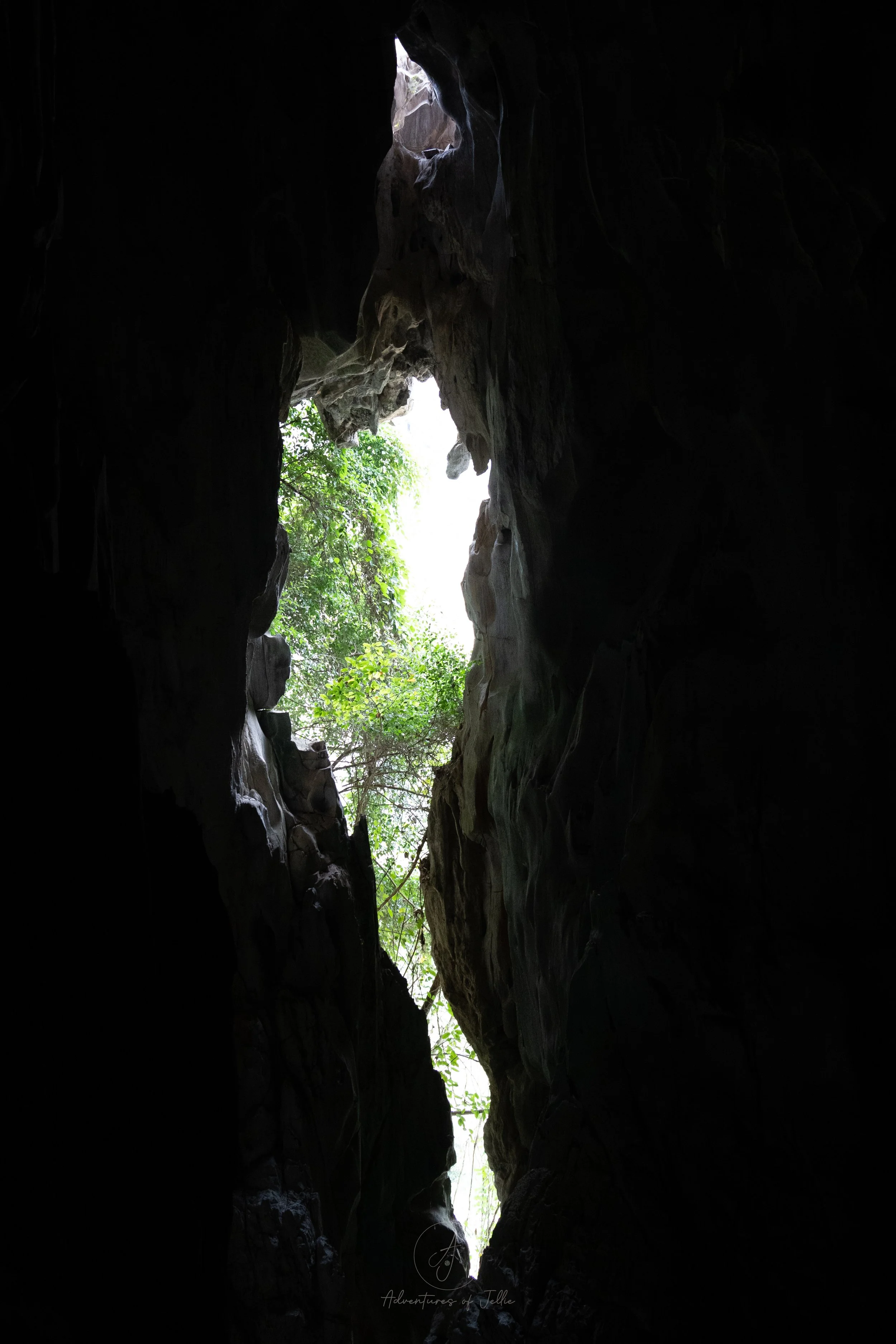 An opening in the cave lets in a slither of light to the near black Phathok Caves in Nong Khiaw, Laos.