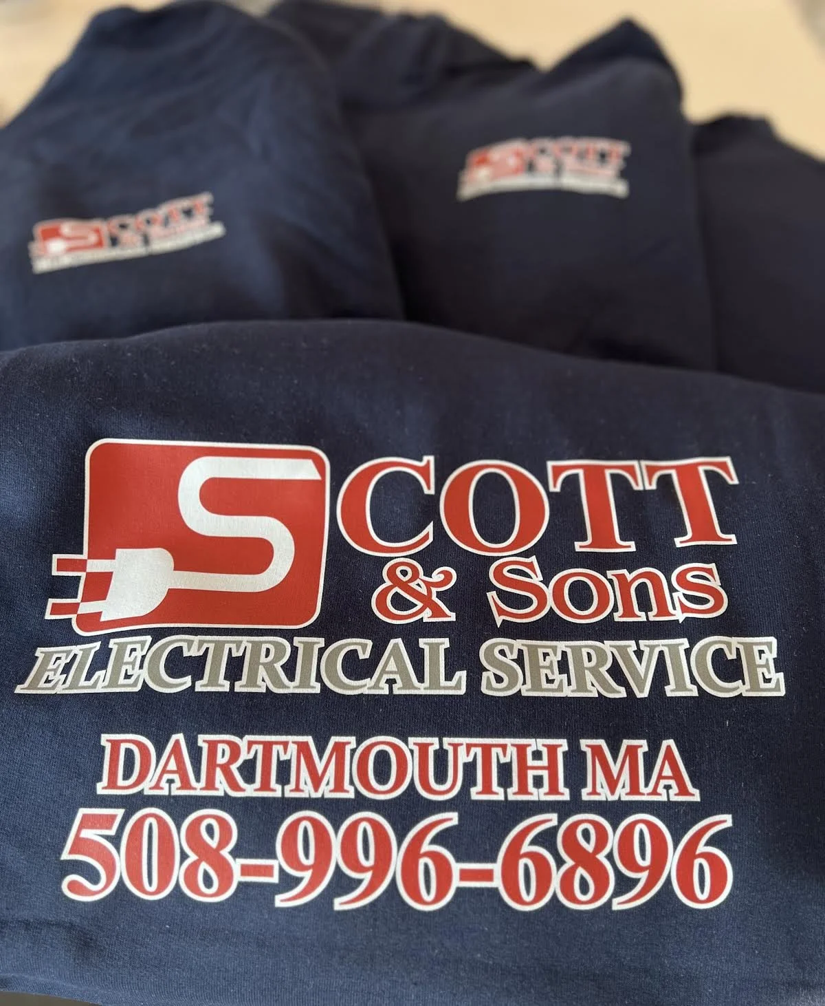 Custom Apparel; DTF: Front, Black and US Flag on Sleeve for Scott & Sons Electrical Service