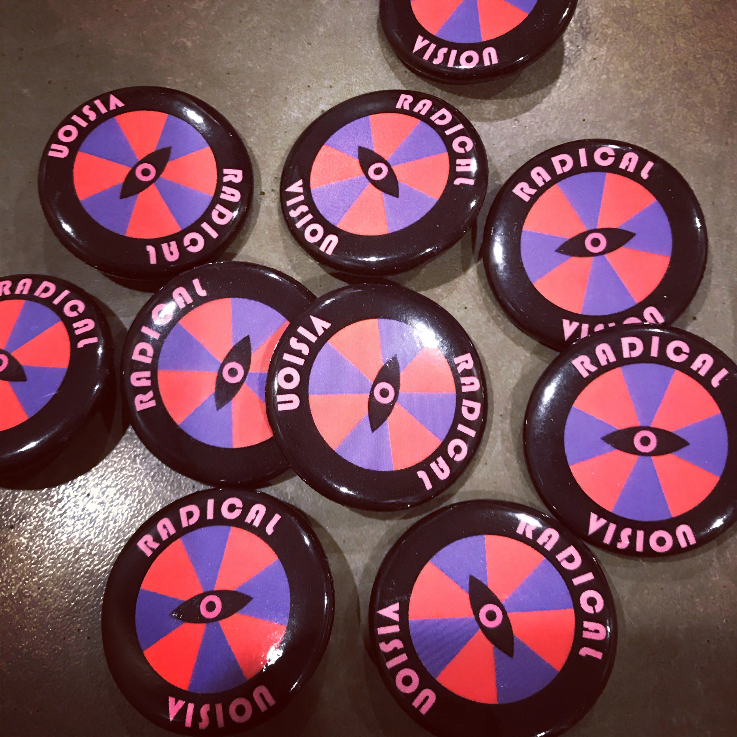 one inch buttons with a wheel and eye design and the text radical vision