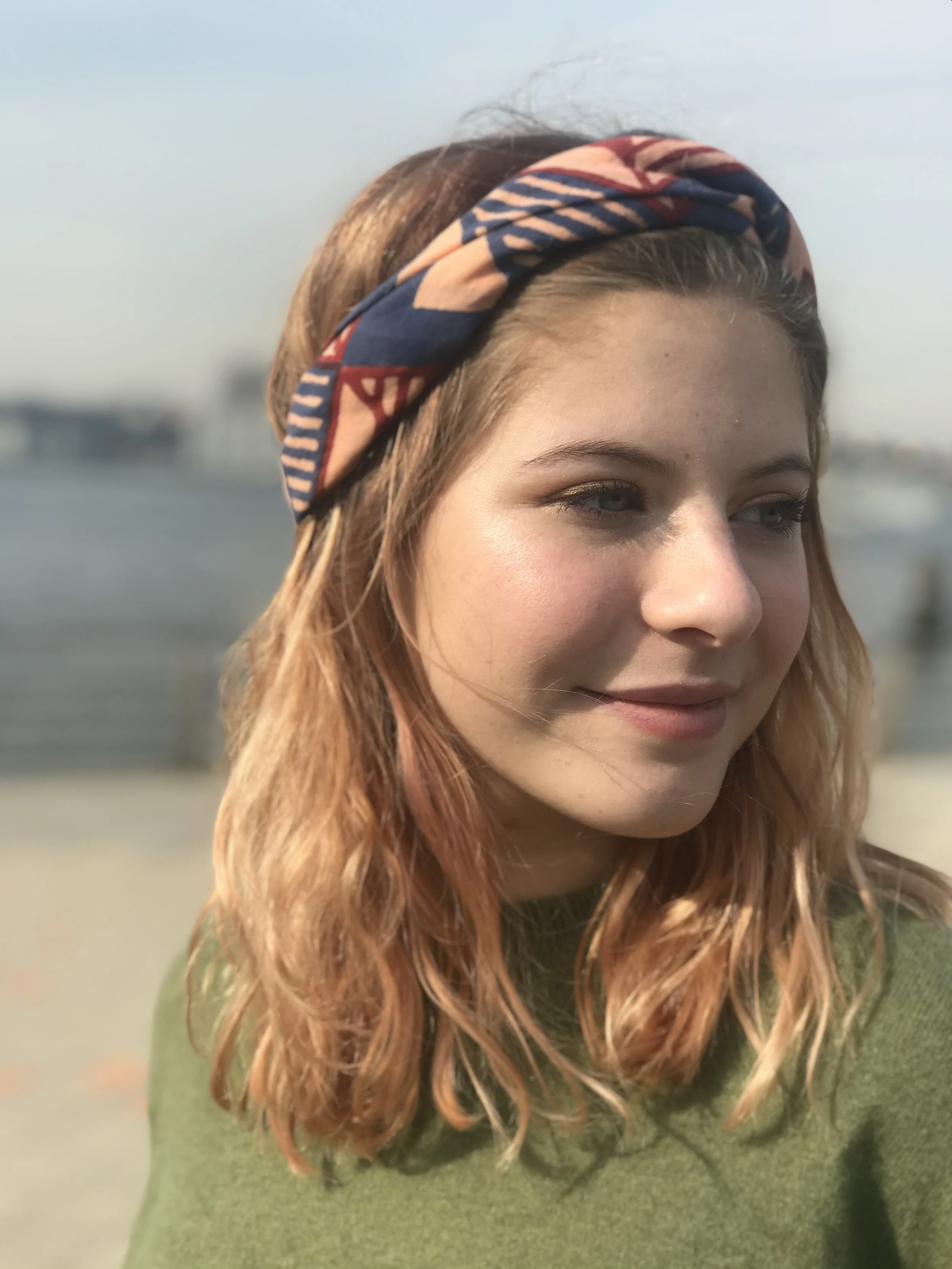 a girl keeps her hair back outside with a bandana around her hair