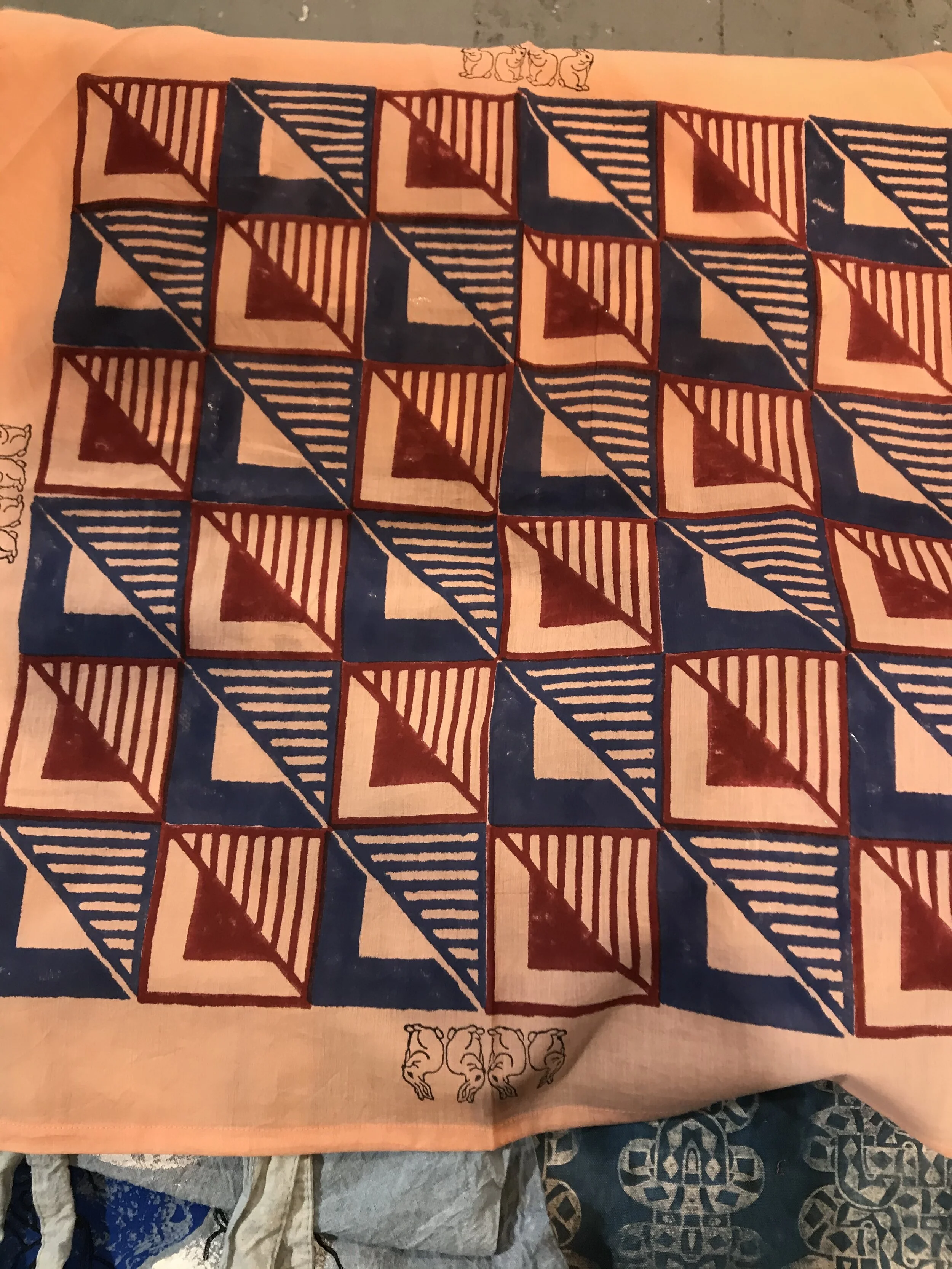 A peach colored bandana with a blue and red check pattern