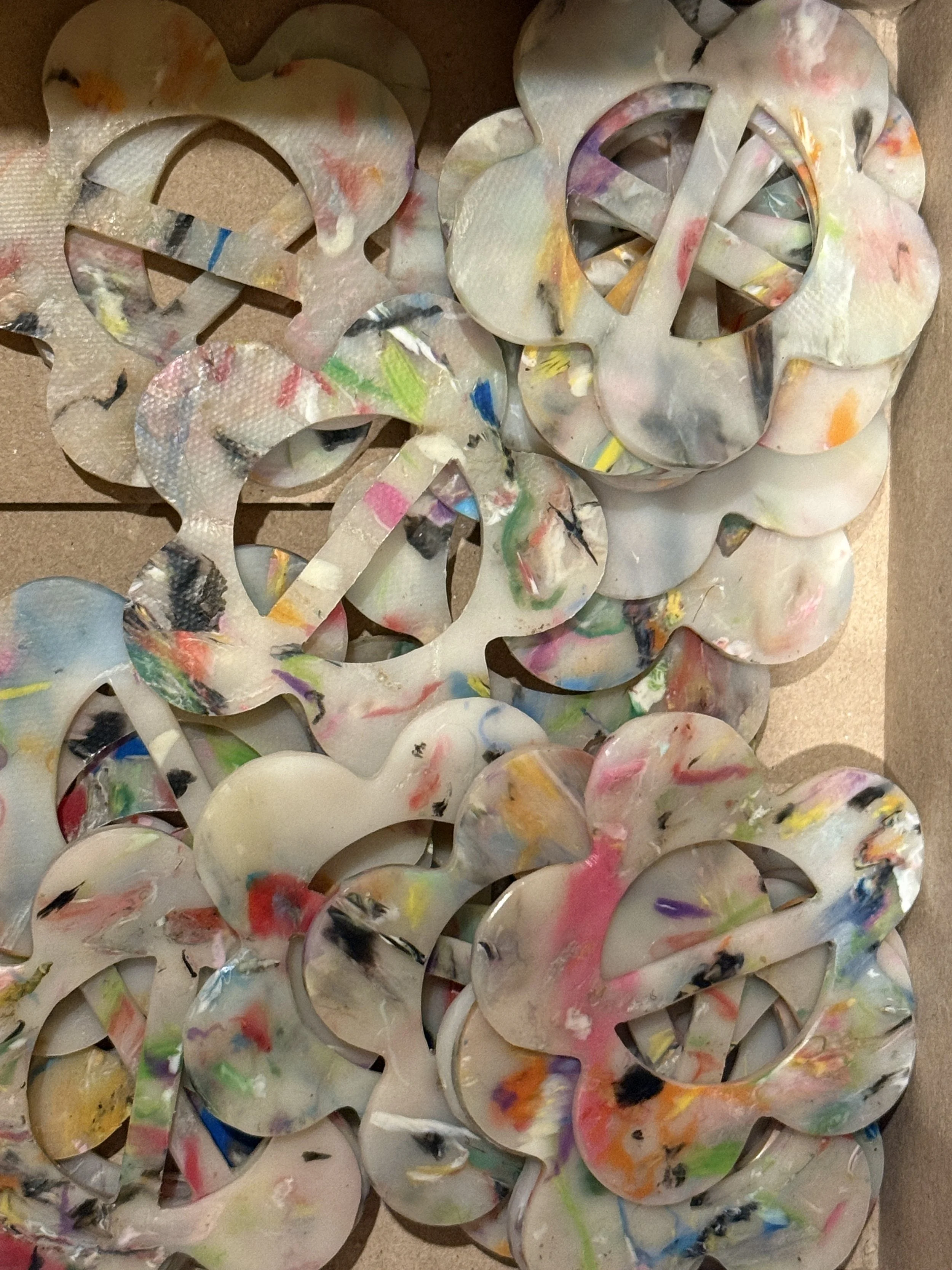 a box of 100% recycled bandana slides made with a confetti style plastic