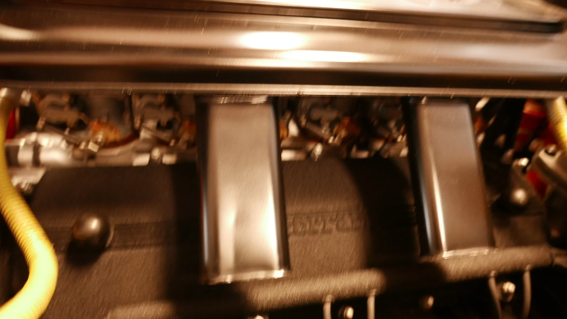 Close-up view of metallic electronic pedals, likely from a vehicle's accelerator, brake, and clutch system.