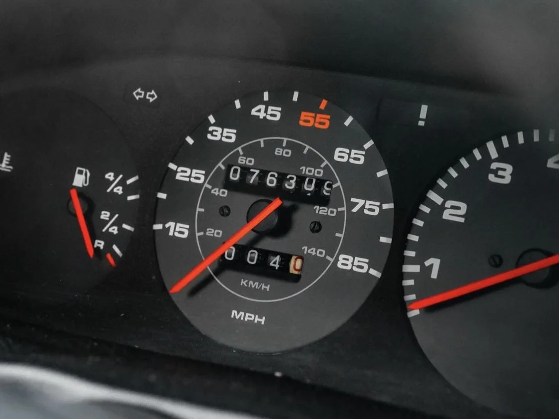Car dashboard showing the speedometer at 75 mph, the tachometer at 1,000 rpm, the fuel gauge around 1/4 tank, and an odometer reading 76,309 miles.