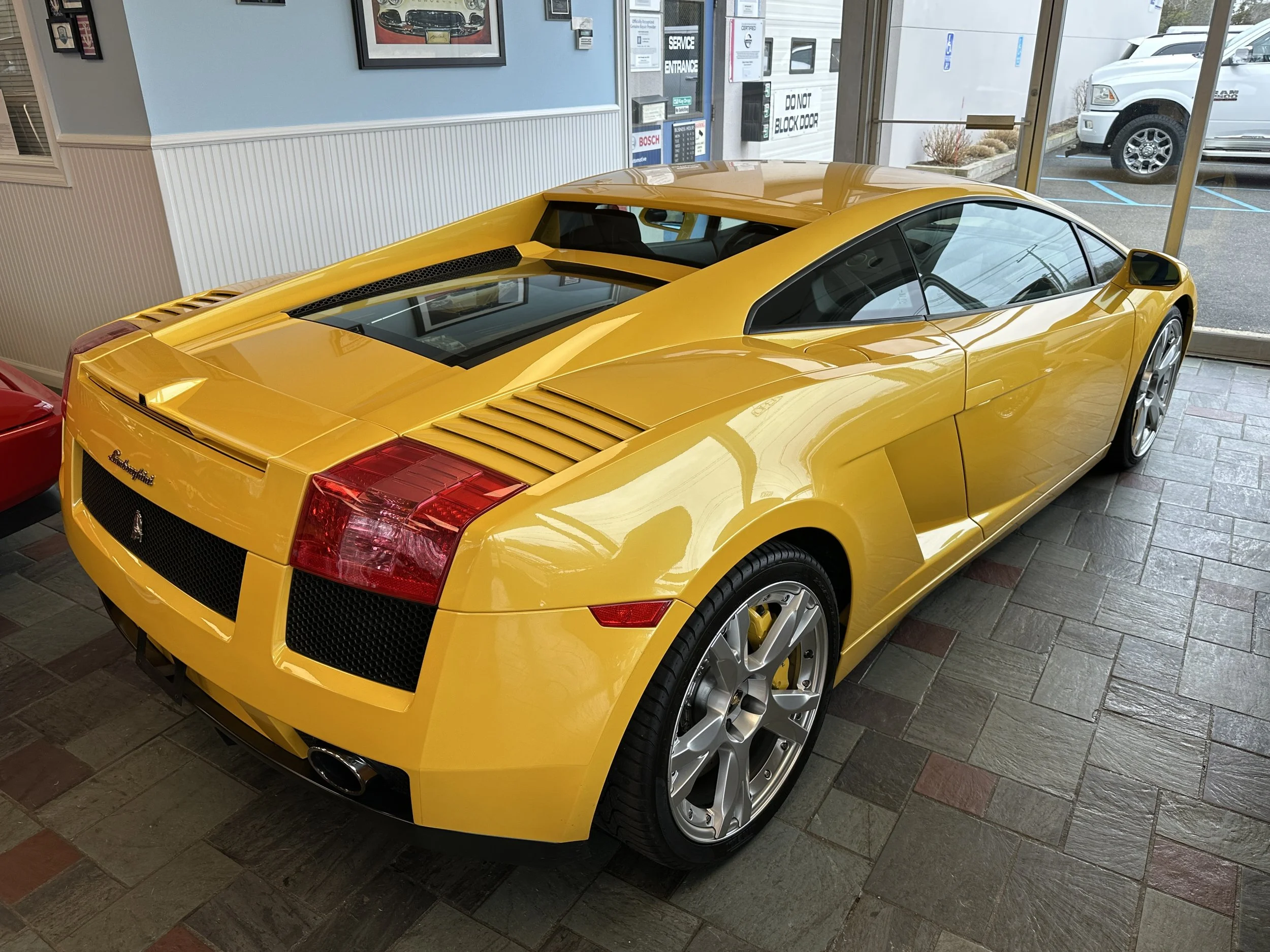 Yellow Lamborghini Gallardo sports car inside a showroom.