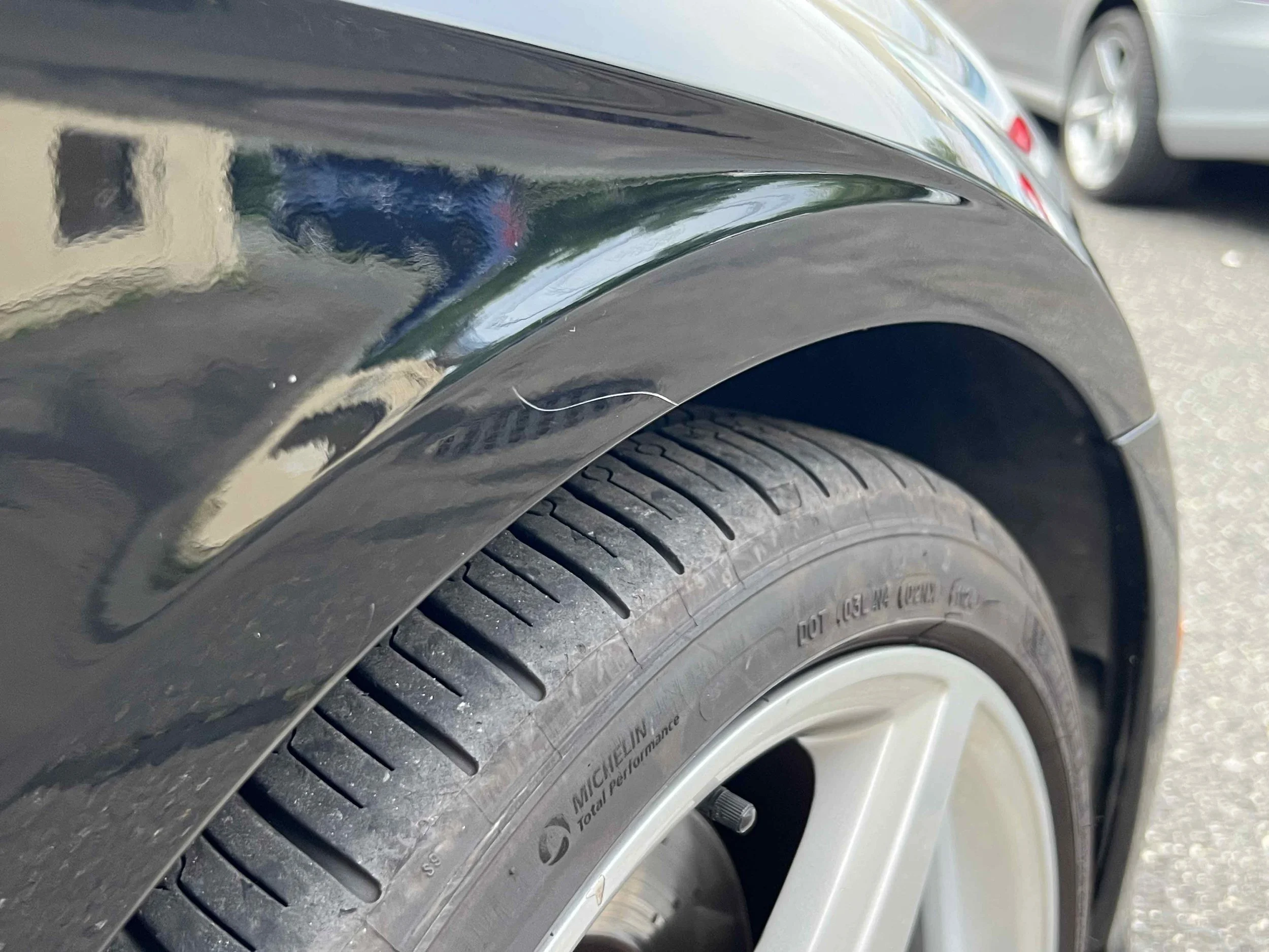 Close-up of a black car's tire and wheel well.