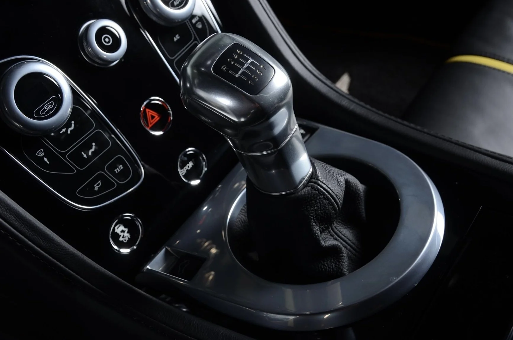 Close-up of a car's interior showing a gear shift lever with a leather boot.