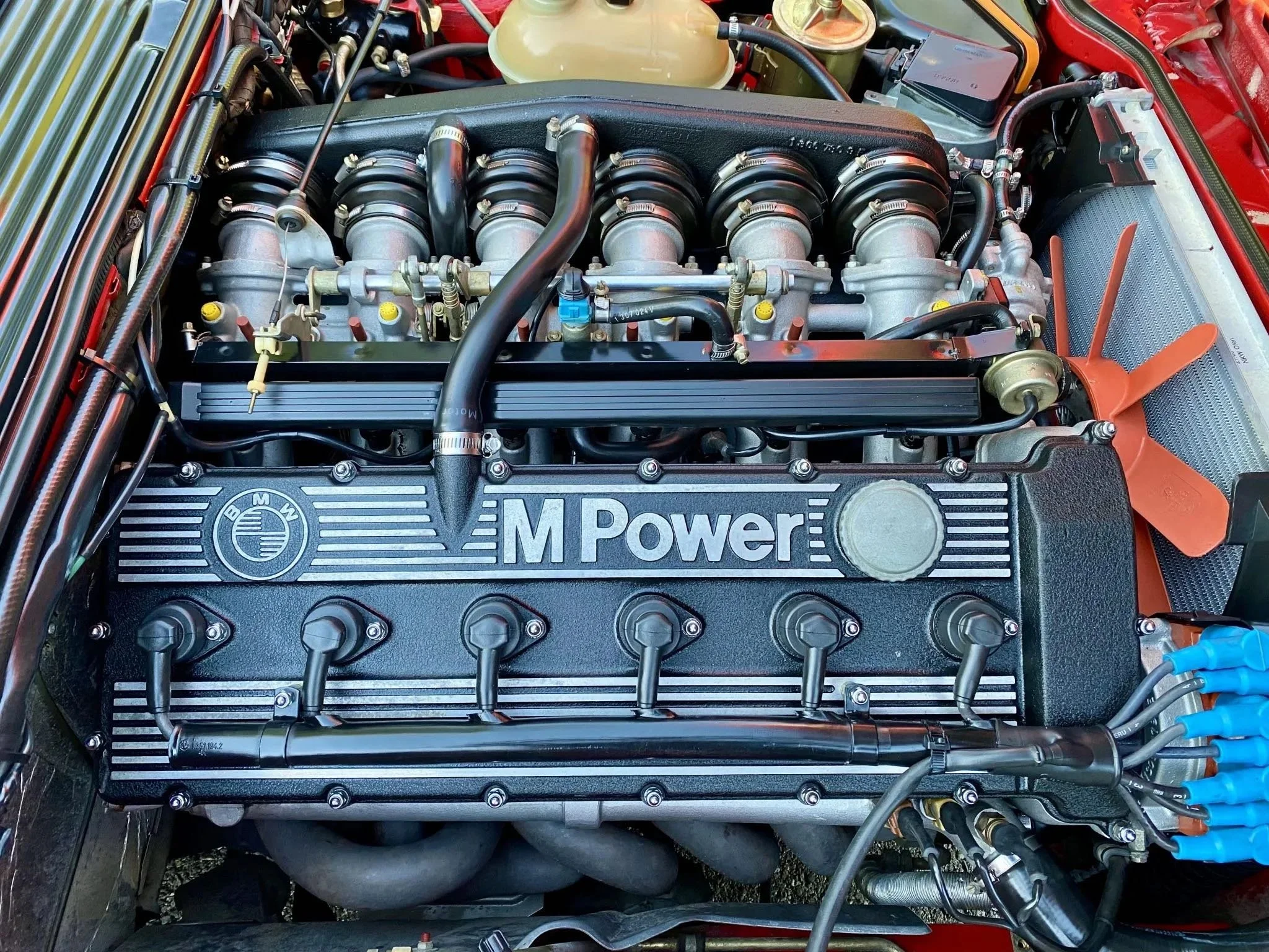 Close-up of a BMW M Power engine with detailed components and orange fan.