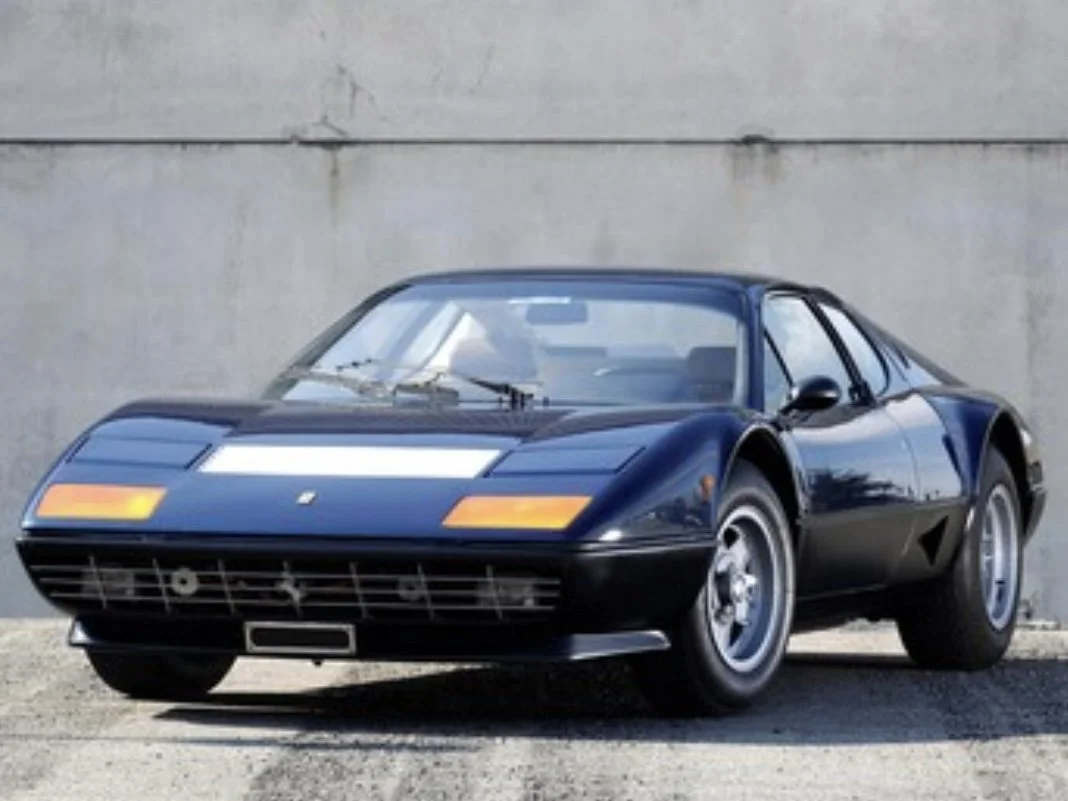 Blue 1979 Ferrari 512 BB on display in front of concrete wall