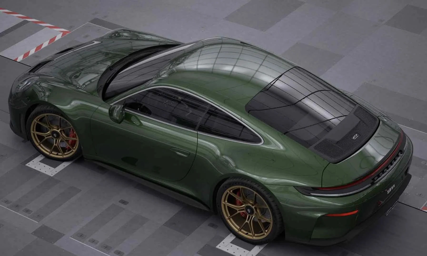 A green Porsche sports car with gold wheels parked inside a building.