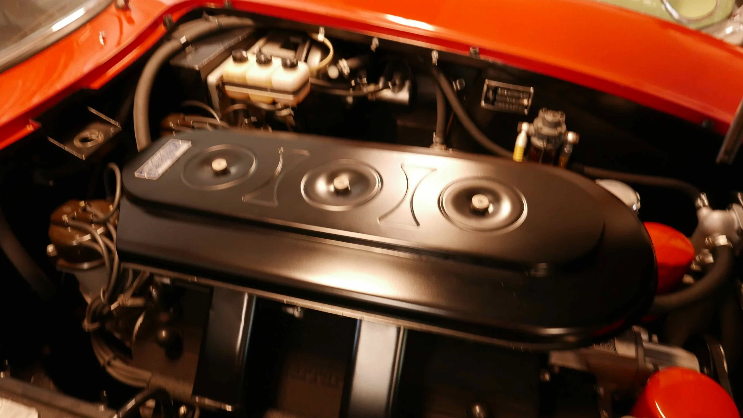 Close-up of a Ferrari engine mounted under the wing of an aircraft, showing the engine nacelle, intake, and visible components.