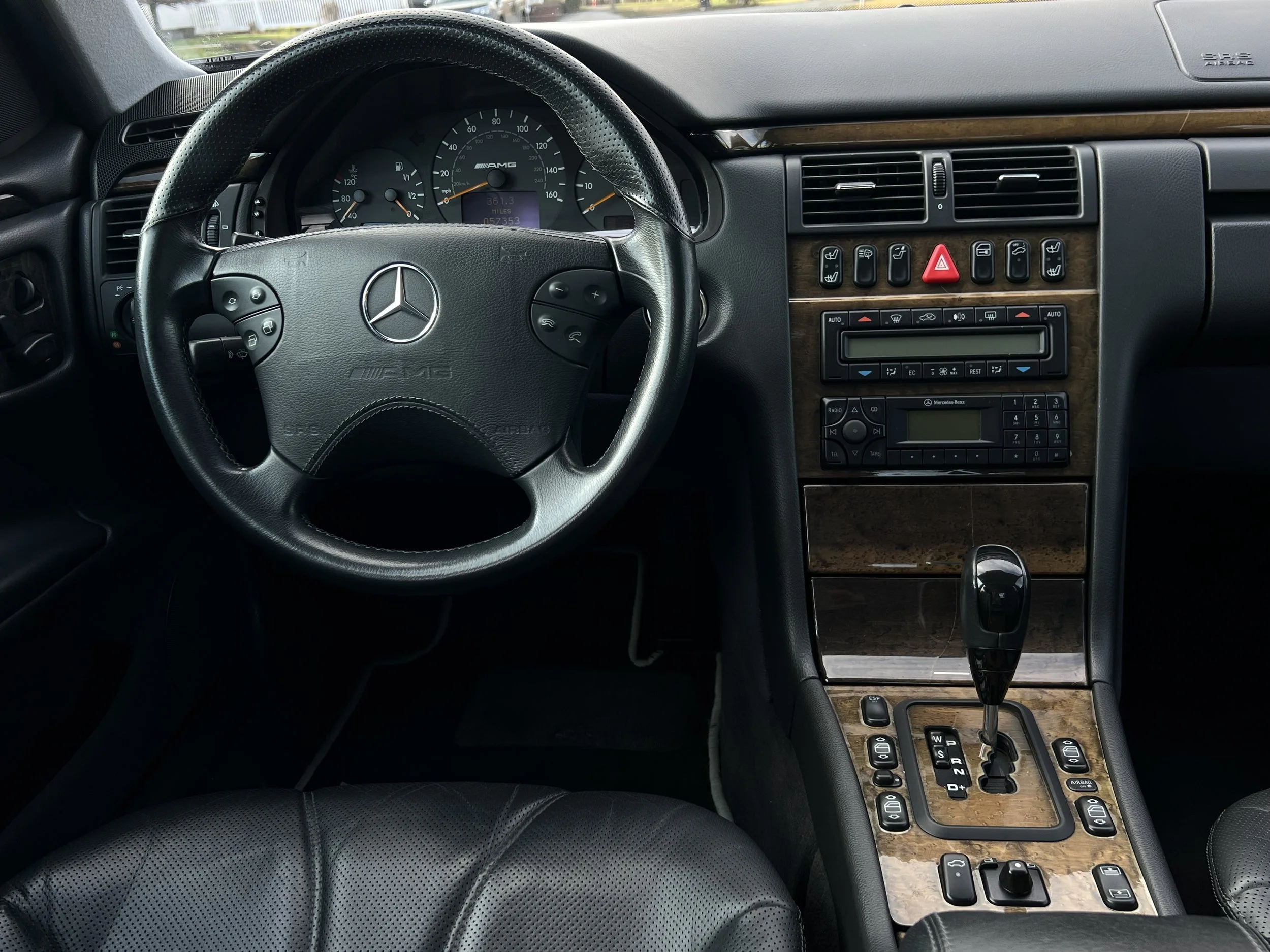 Interior of a luxury Mercedes-Benz vehicle, showing the dashboard, steering wheel, gear shift, and control panel with various buttons and displays.