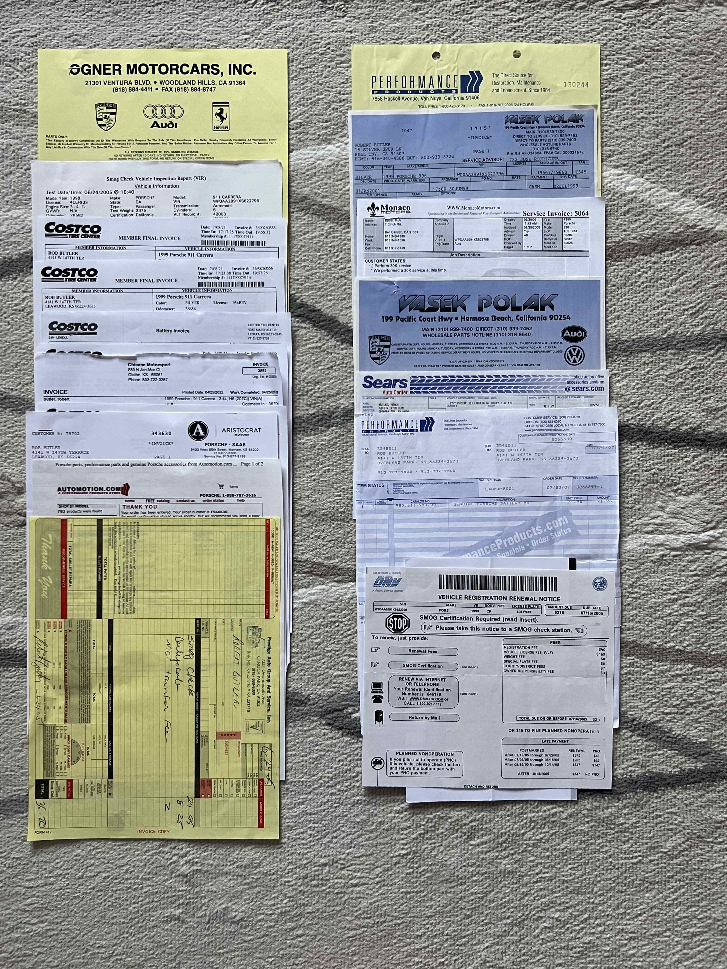 A collection of vehicle-related documents, including invoices, receipts, and notices, spread out on a textured surface. The documents contain text and logos from various automotive companies and services.
