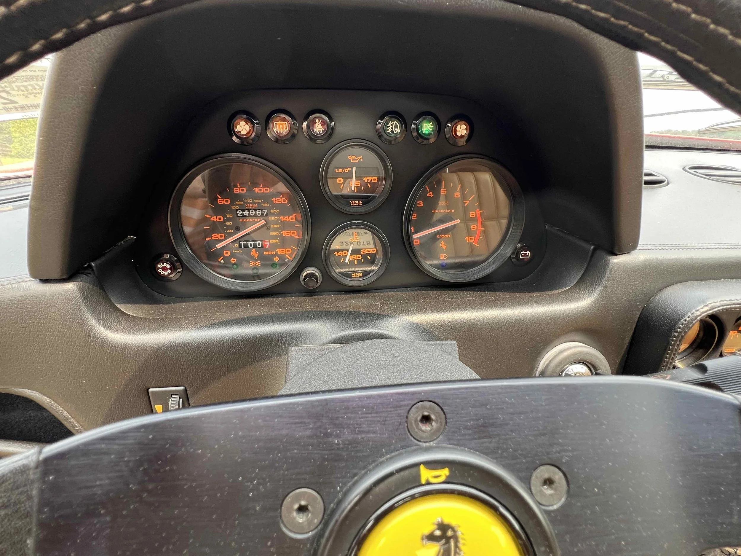 Car dashboard showing speedometer, tachometer, oil pressure, and other gauges and indicator lights.