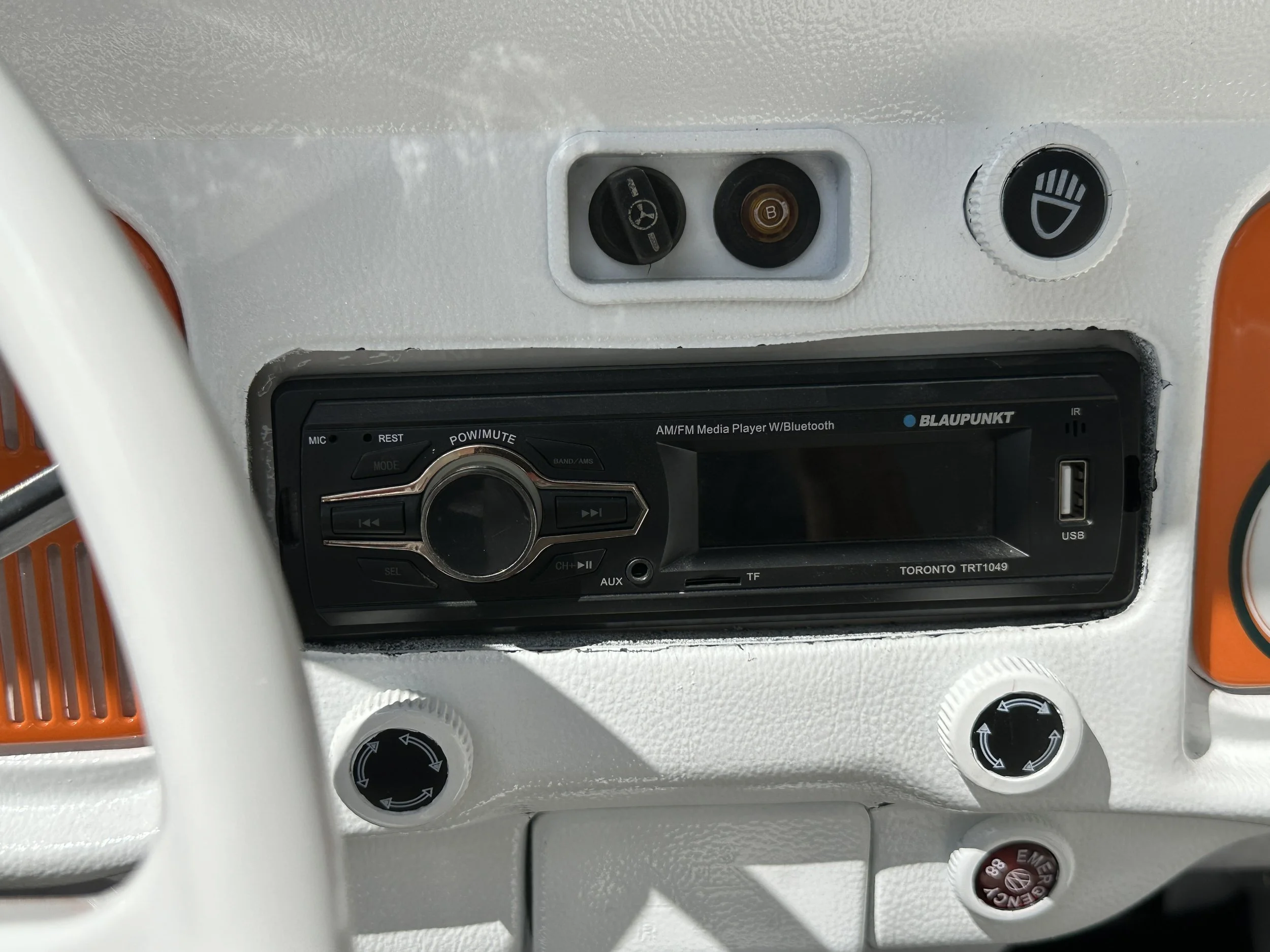 Dashboard of a vehicle with a Blaupunkt media player, climate control dials, and switches for lights and emergency functions.